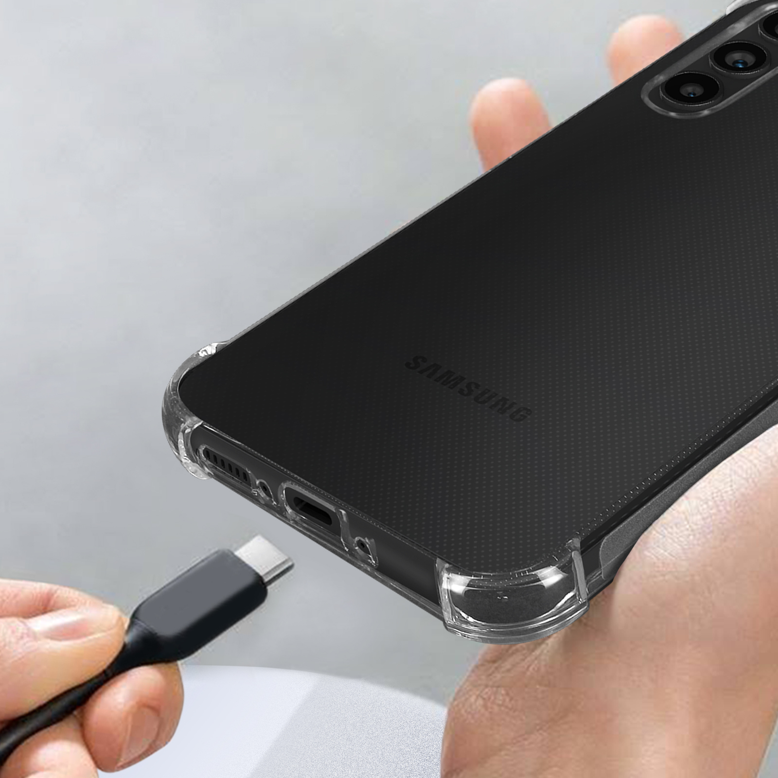 Un doigt tient un câble USB-C près d'une coque de téléphone transparente.