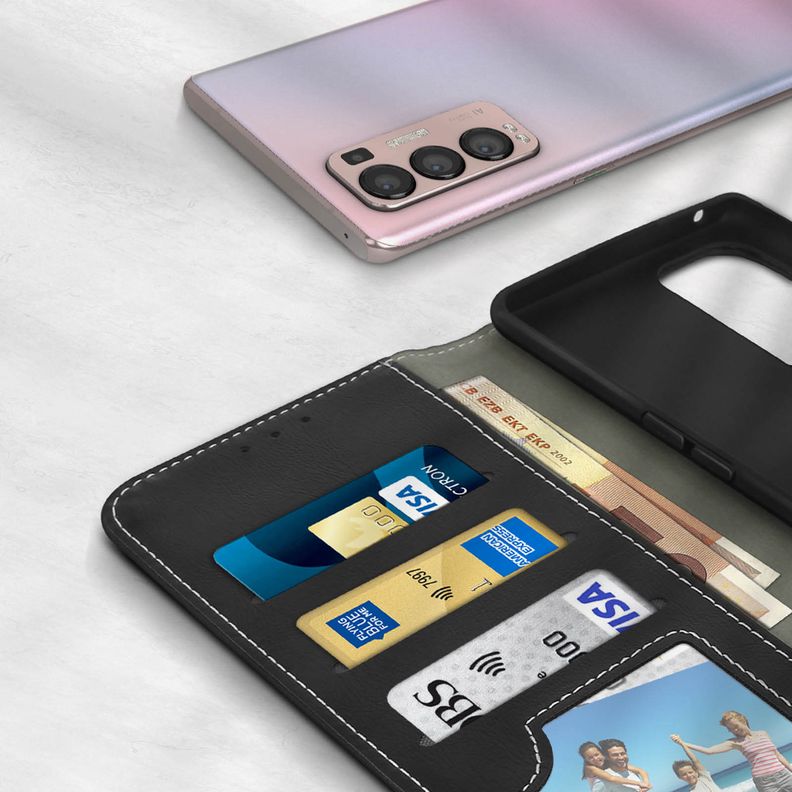 Een roze smartphone ligt boven een zwarte portemonnee met kaarten en bankbiljetten.