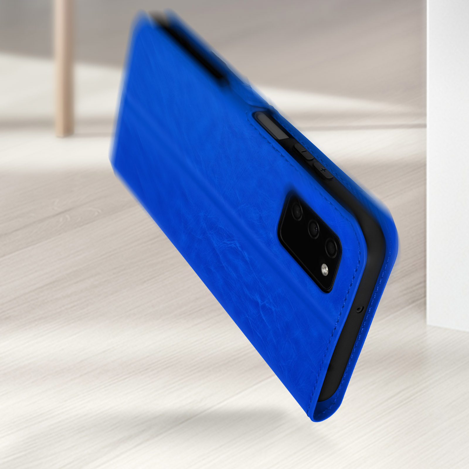 Een levendige blauwe boekstijl telefoonhoes met camera's op een lichte houten vloer.