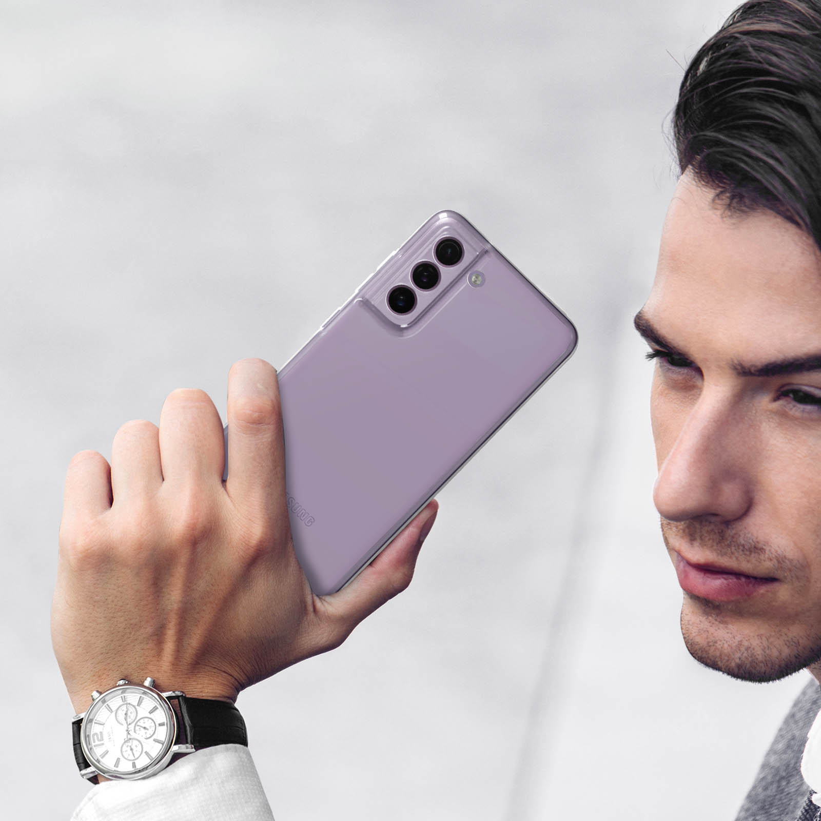 Un uomo tiene in mano uno smartphone lavanda con tre fotocamere.
