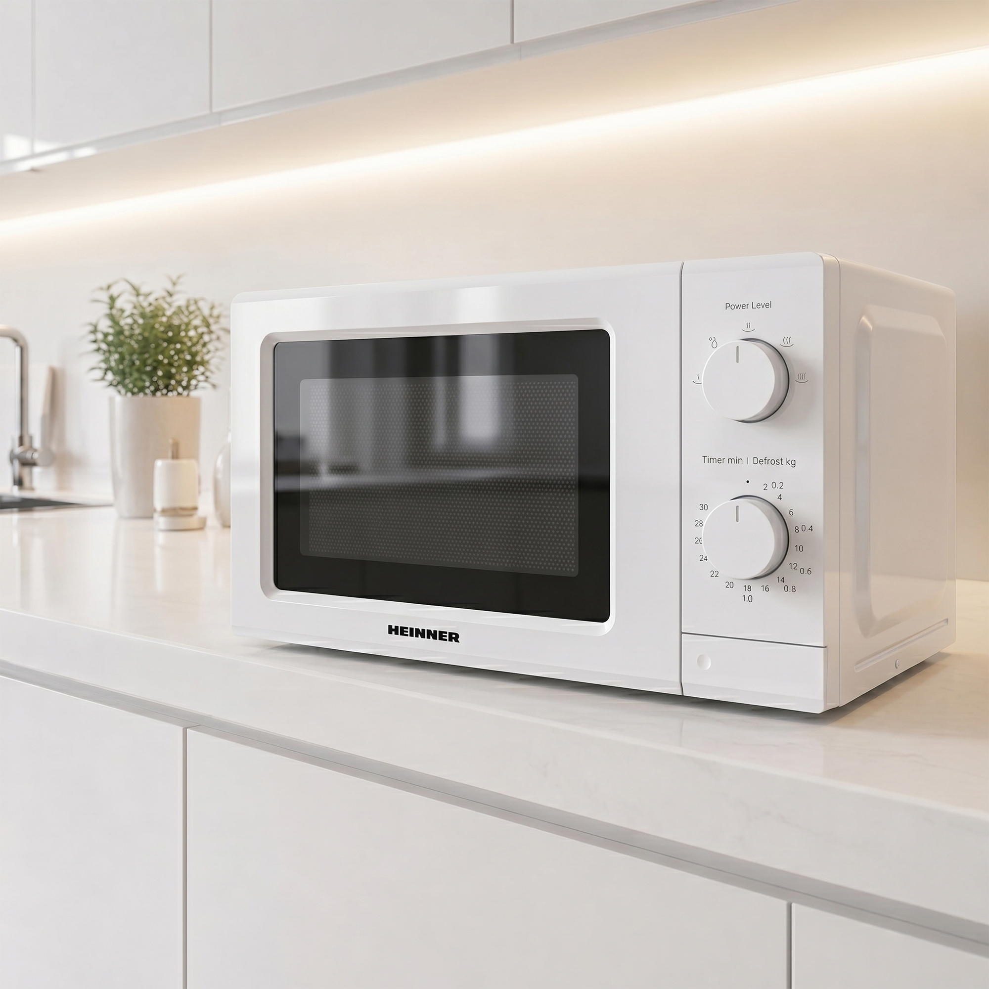 A white HEINNER microwave sits on a countertop with knobs.