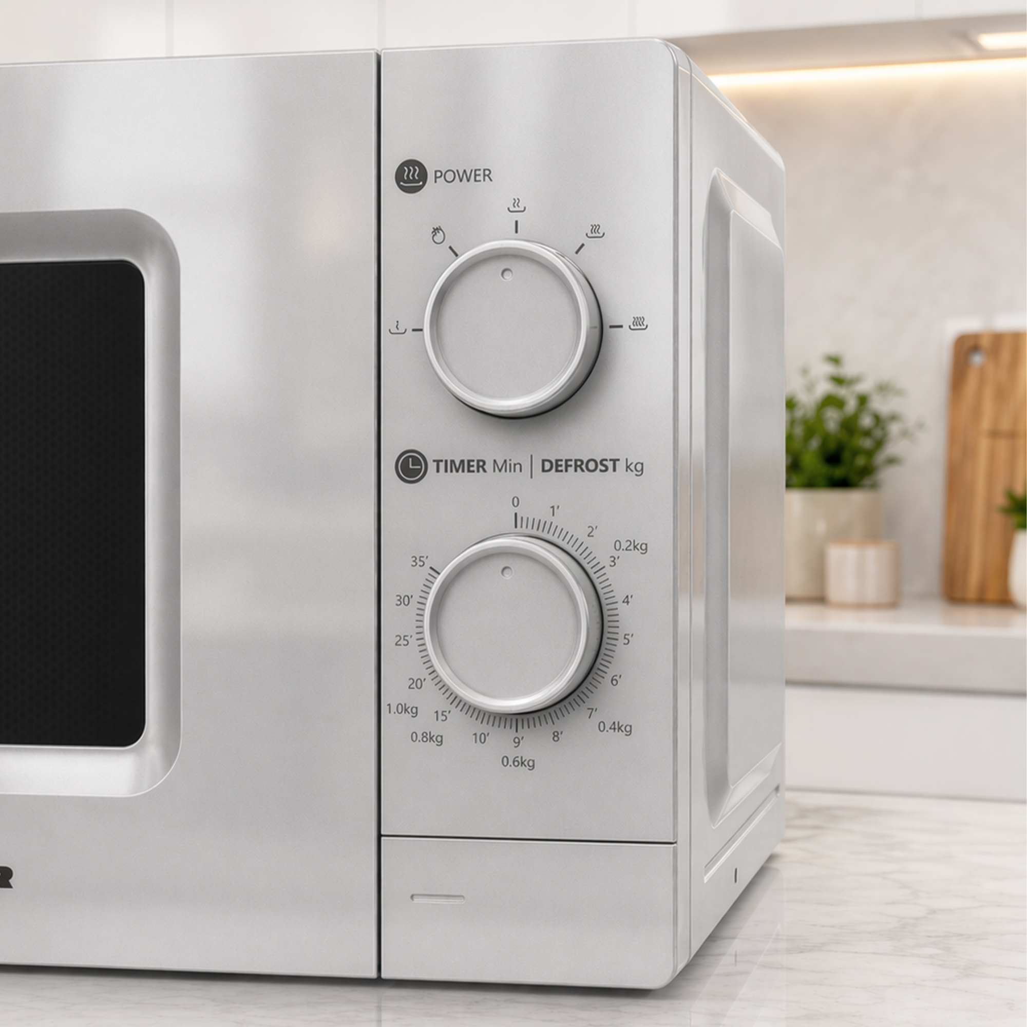 Silver microwave with control dials for power, timer, and defrost. On marble surface.