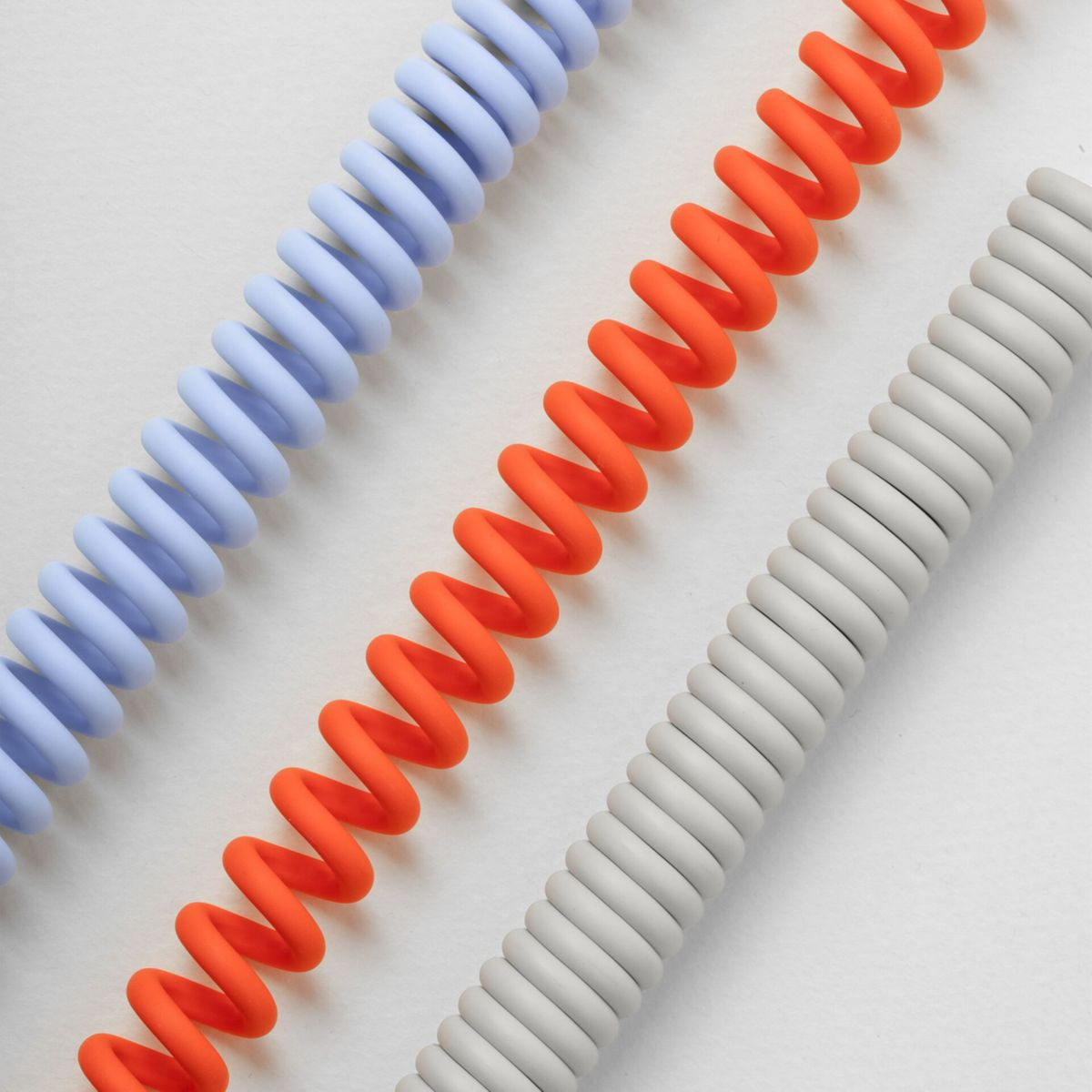 Trois câbles en spirale bleu, orange et gris sur fond blanc.