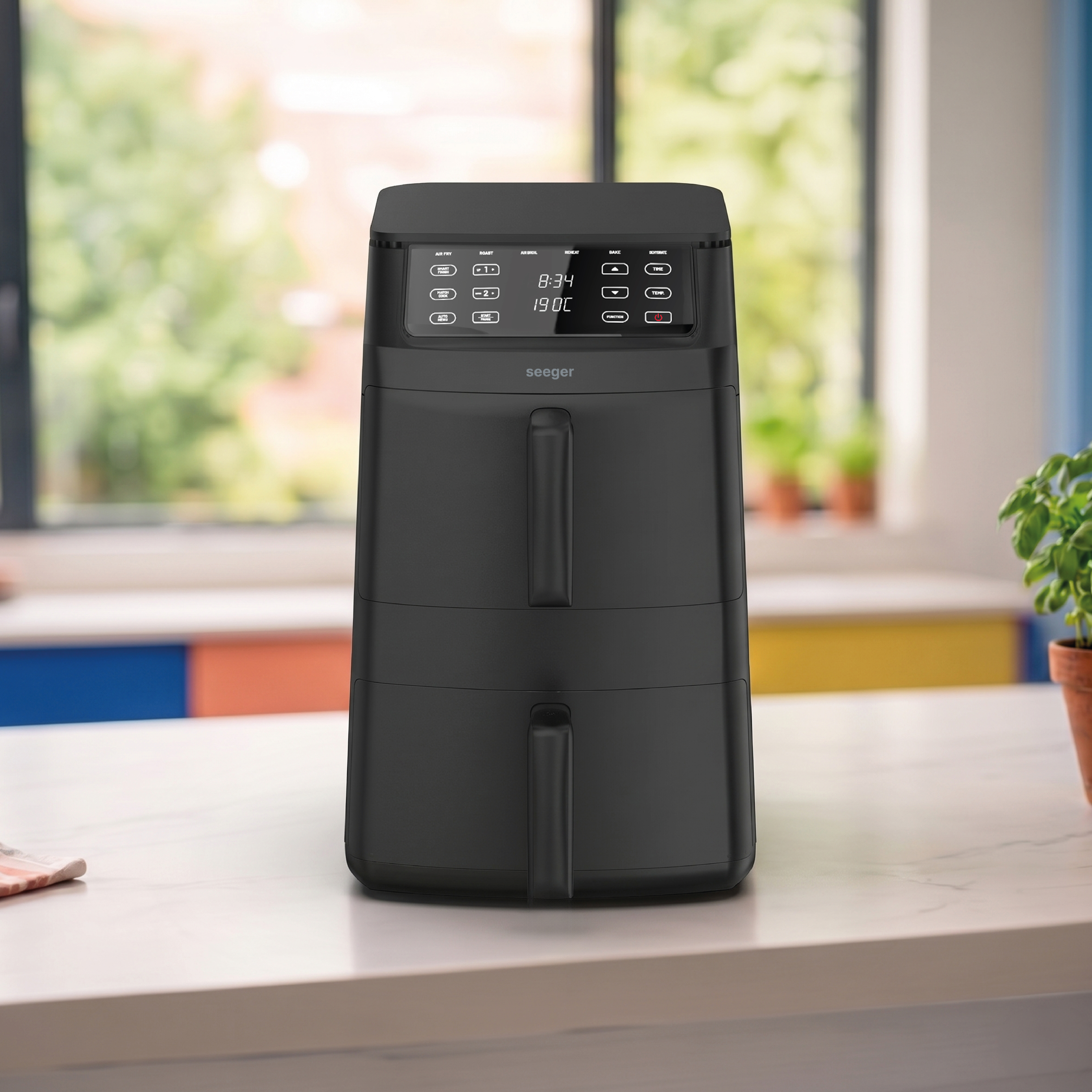 A black, double-chamber Seeger air fryer with a digital display sits on a marble countertop.
