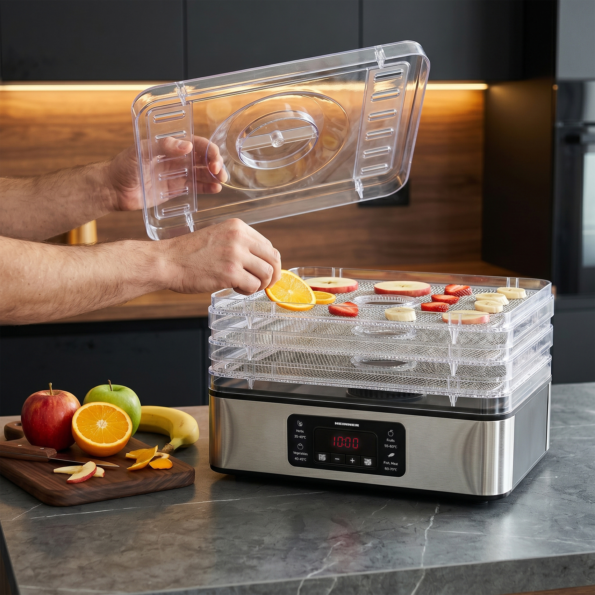 Une personne dépose une tranche d'orange sur un déshydrateur de fruits.