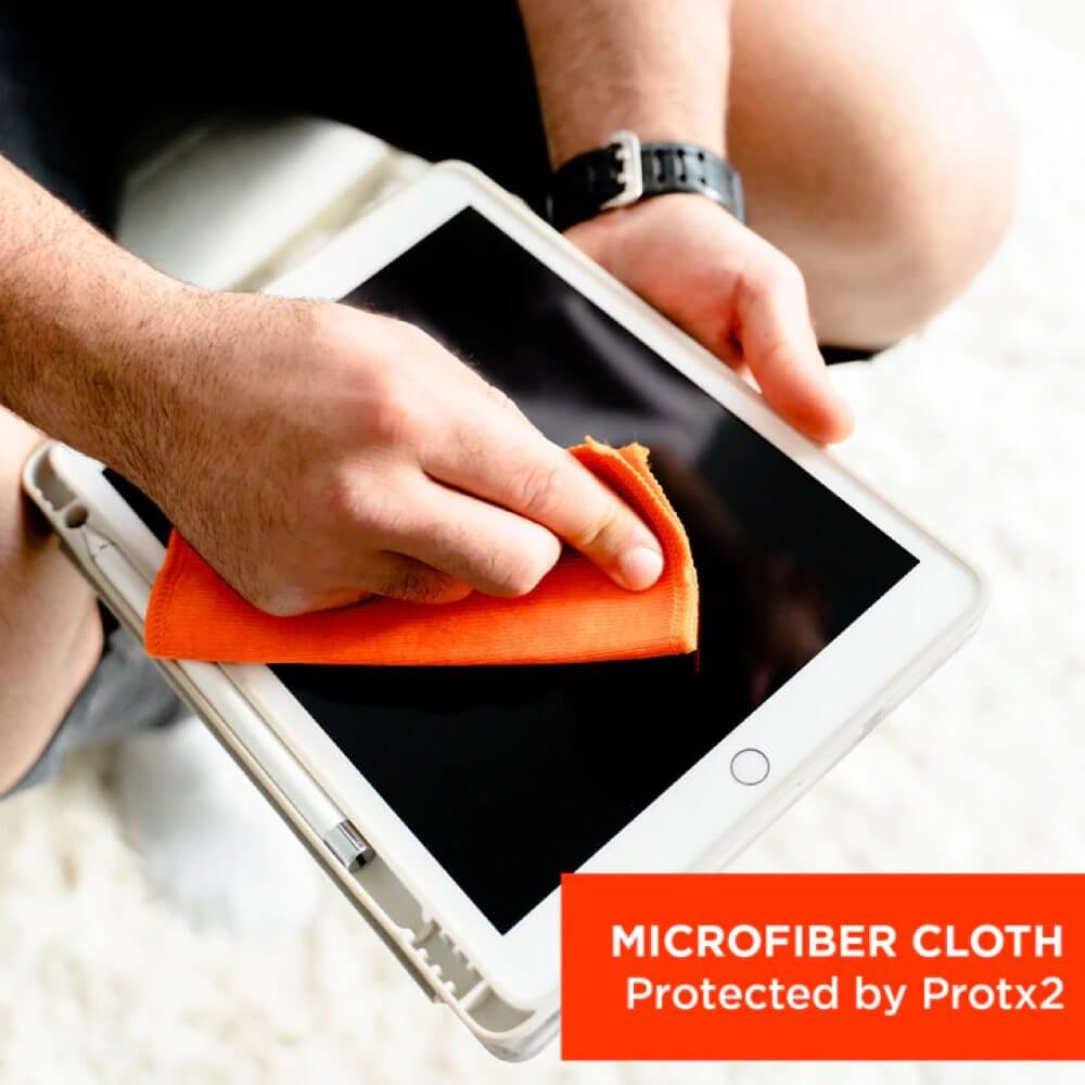 Een hand veegt een tabletscherm schoon met een oranje microvezeldoek.