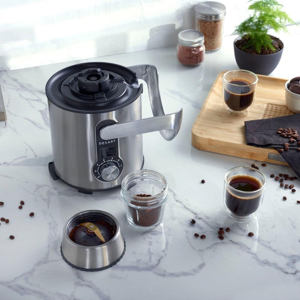 Mermer tezgahta paslanmaz çelik kahve öğütücü, kahve çekirdekleri ve espresso ile.