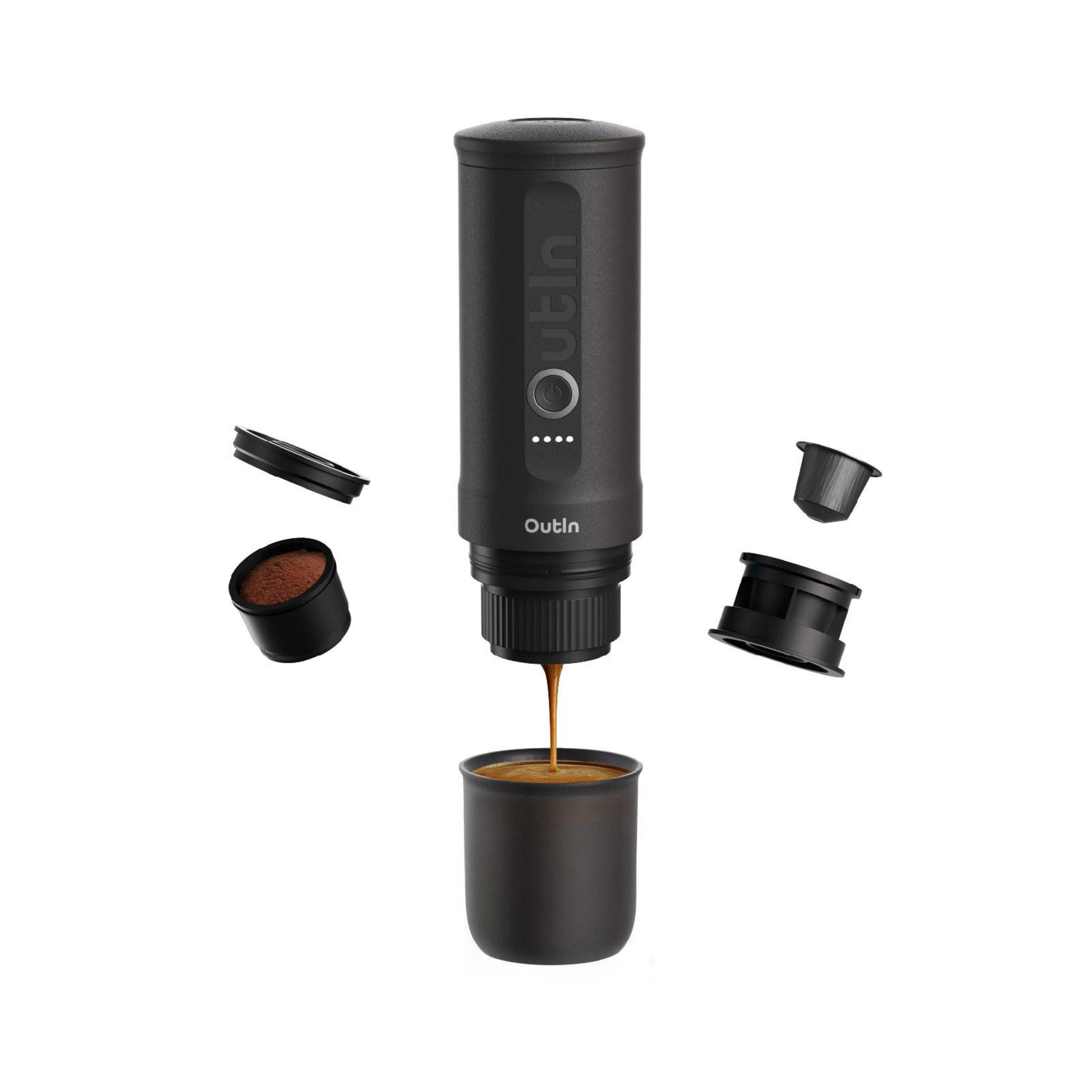 Una caffettiera nera con espresso che scorre in una tazza. Accessori accanto.