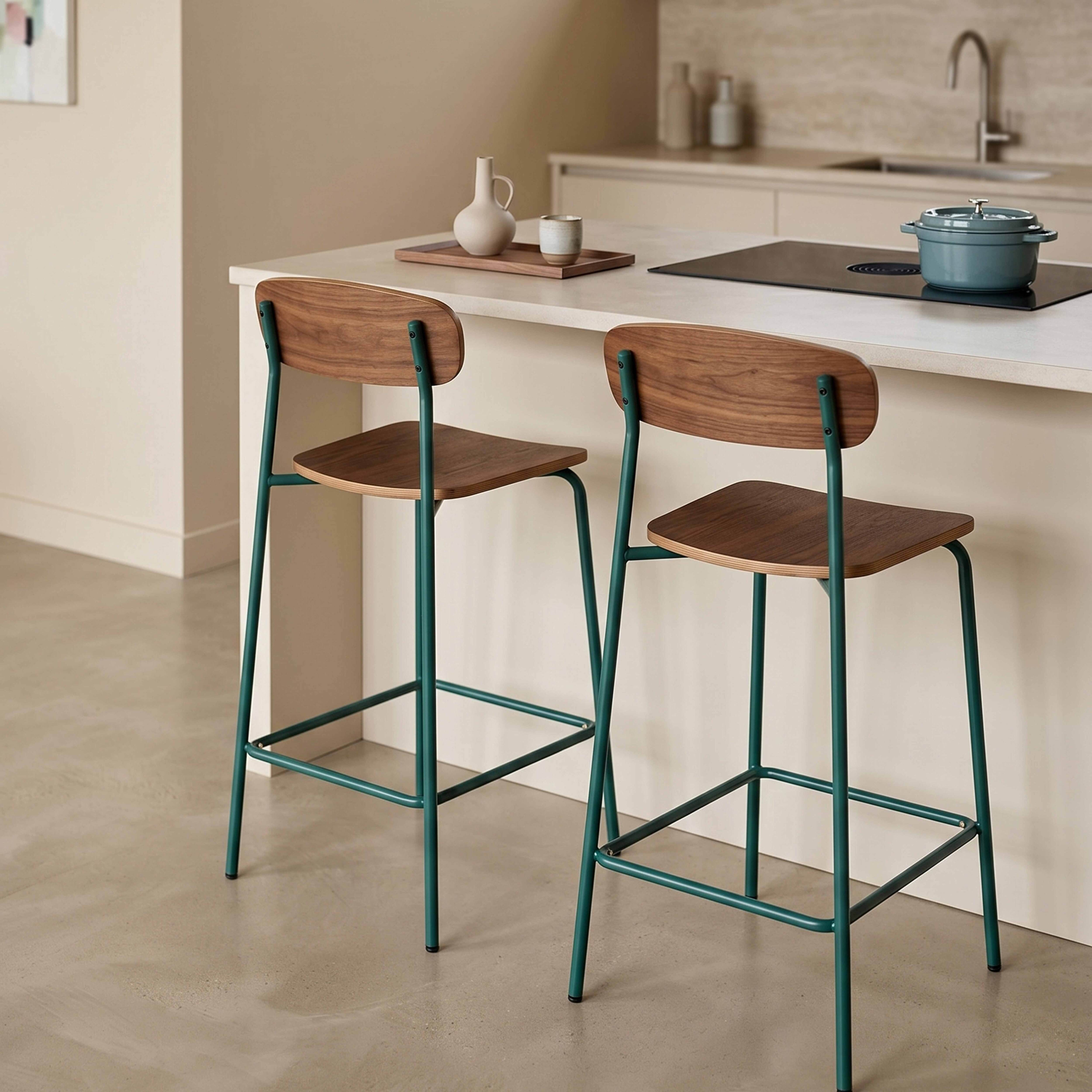 Zwei Barhocker mit Holzsitzen und dunkelgrünen Metallgestellen stehen an einer Küchentheke.