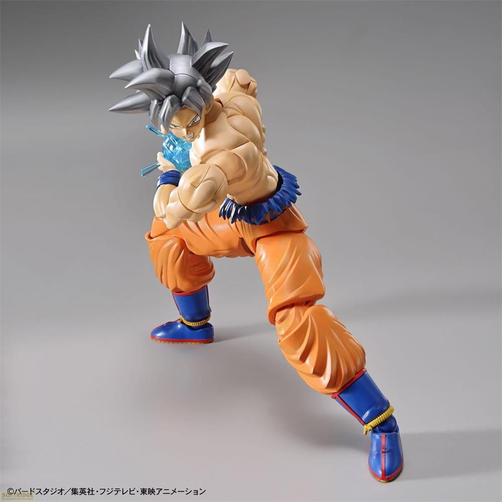 Figurine de Goku en Ultra Instinct, pantalon orange, bottes bleues, charge une attaque d'énergie bleue.