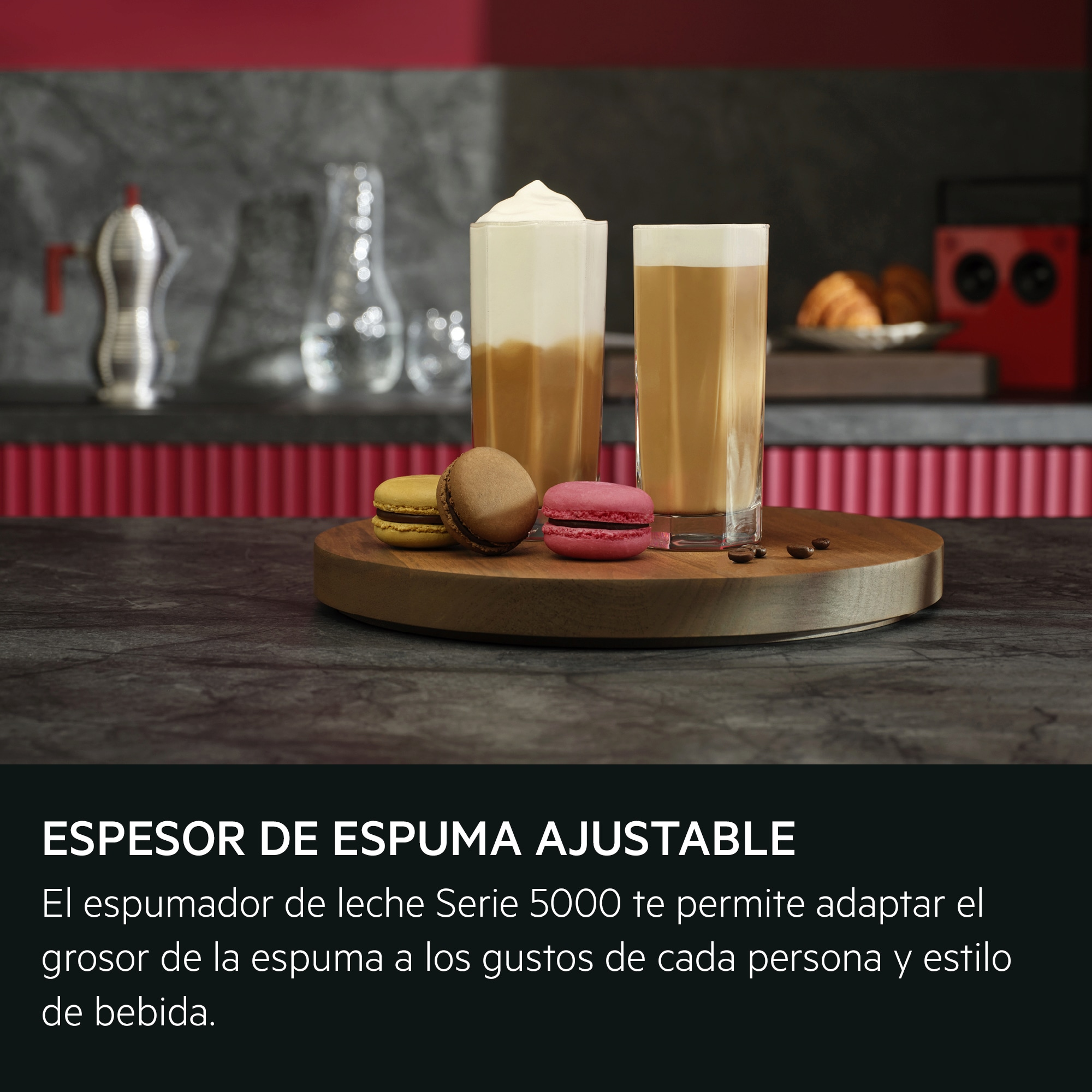 Zwei hohe Gläser Kaffee mit Schaum, drei Macarons auf einem Holzbrett und Kaffeebohnen.