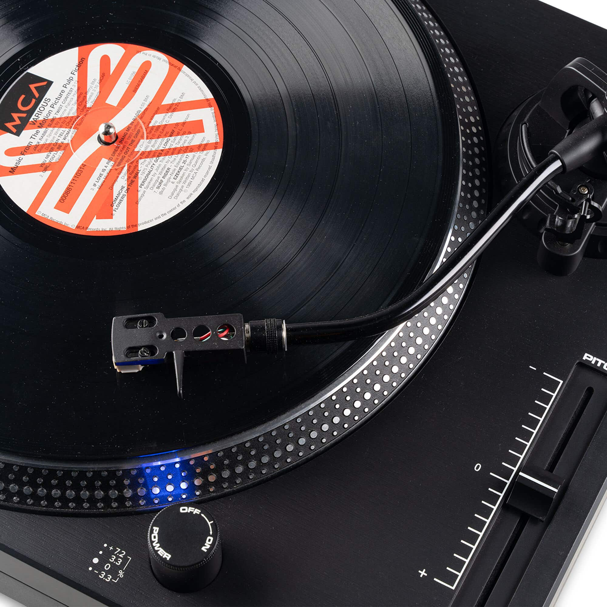 Un tocadiscos negro con un disco de vinilo reproduciéndose.