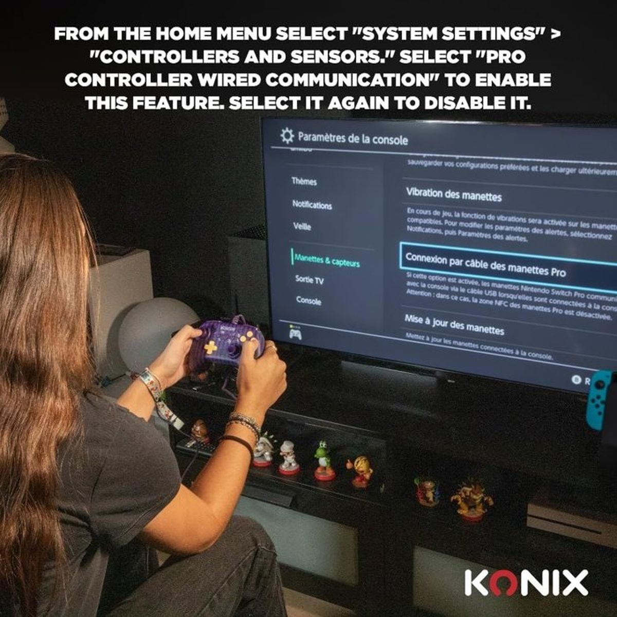 Una persona tiene un controller viola, guardando uno schermo TV con impostazioni di sistema.