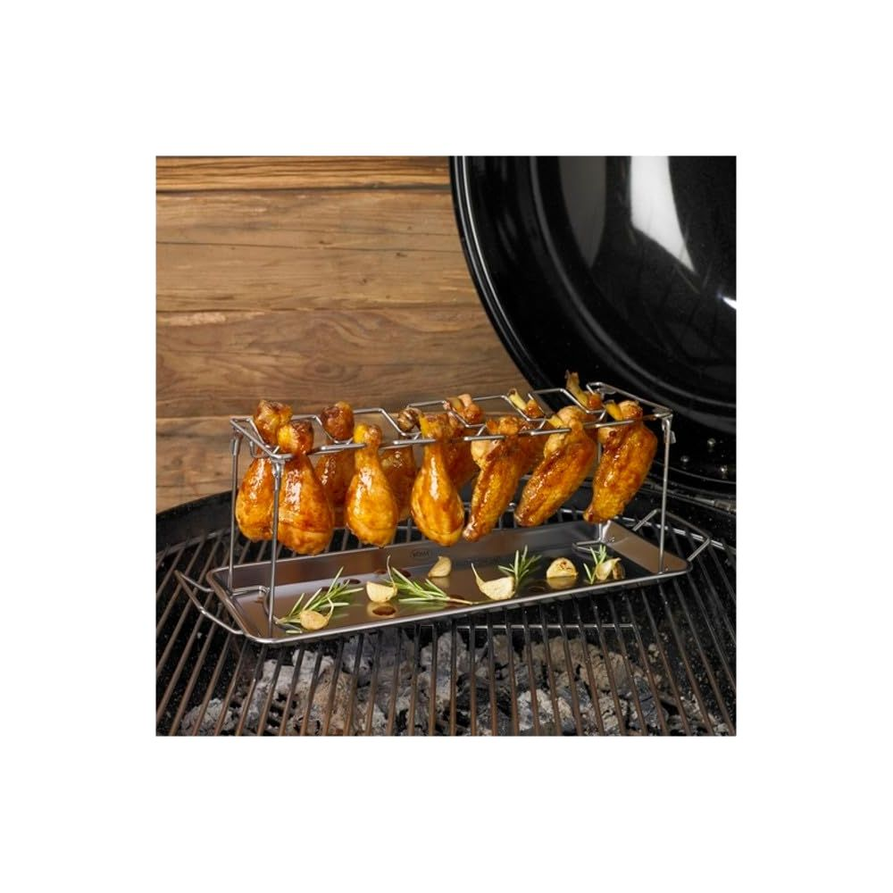 Hähnchenschenkel und Flügel auf einem Grillständer mit Rosmarin und Knoblauch.