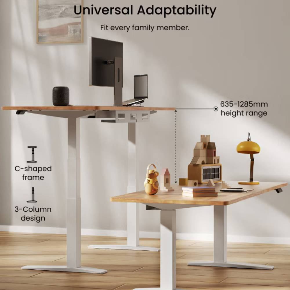 Zwei höhenverstellbare Schreibtische mit Holzoberfläche, ein größerer mit Monitor und Laptop, ein kleinerer mit Spielzeug und Lampe.