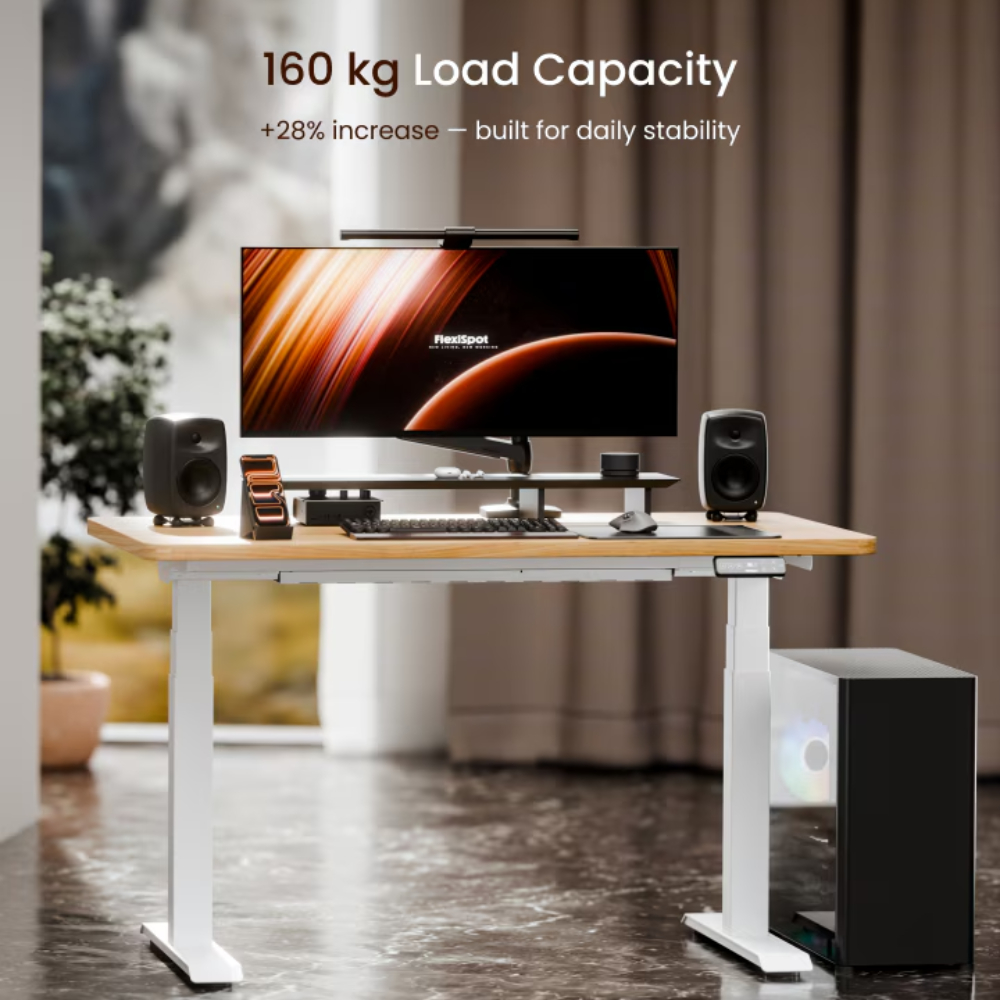 Ein weißer Sitz-Steh-Schreibtisch mit Computer, Lautsprechern und Monitor. 160kg Kapazität.