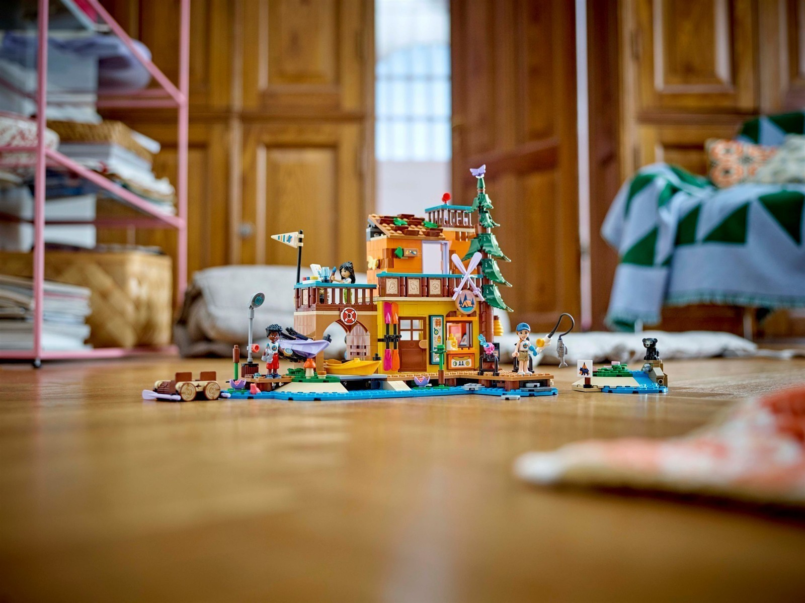 Ein Lego-Ferienhaus mit Figuren, Booten, Angelruten und einem Baum.