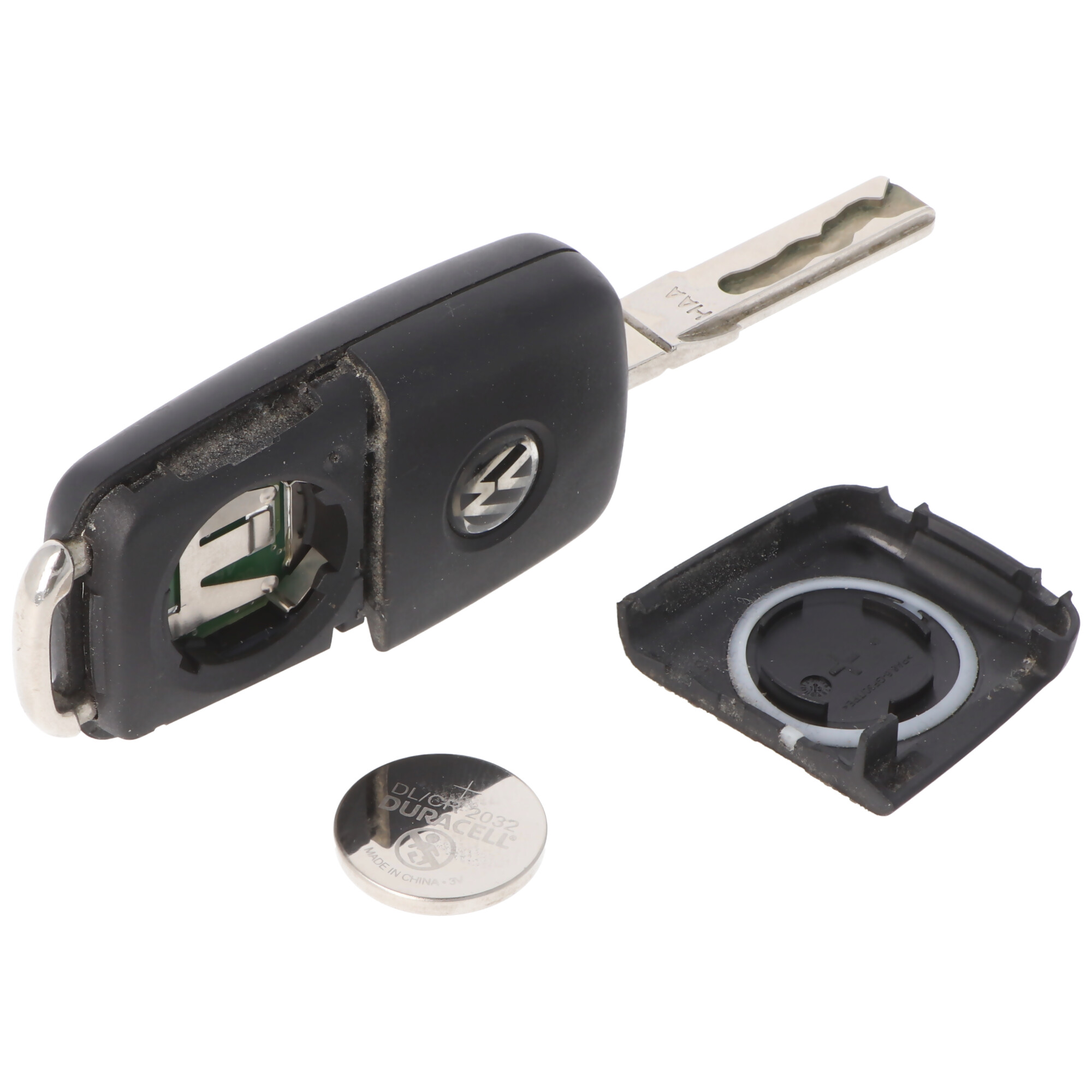 Una chiave per auto nera smontata con batteria e parte di cassa.