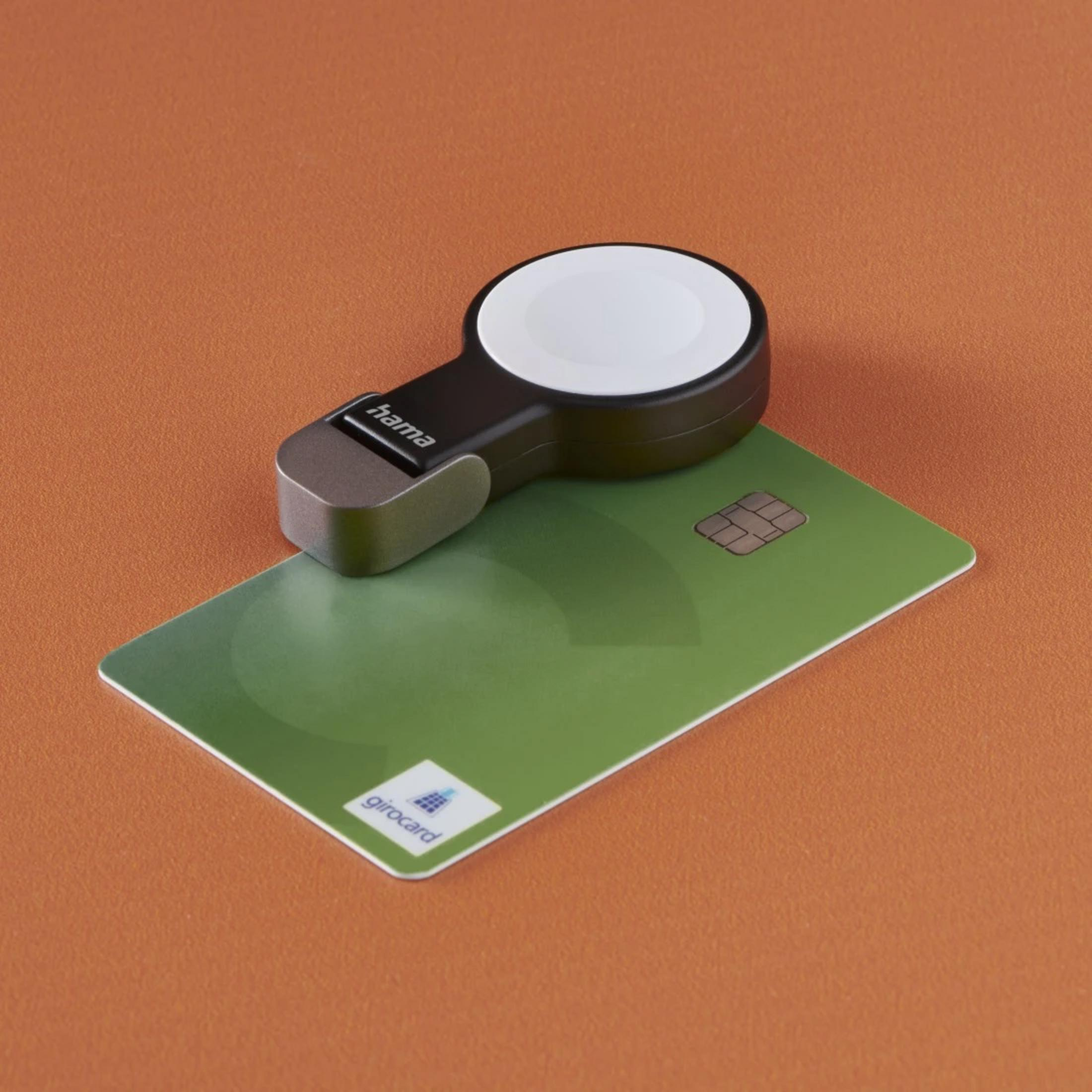 Ein schwarzer Hama Lade-Puck liegt auf einer grünen Girocard mit Chip.
