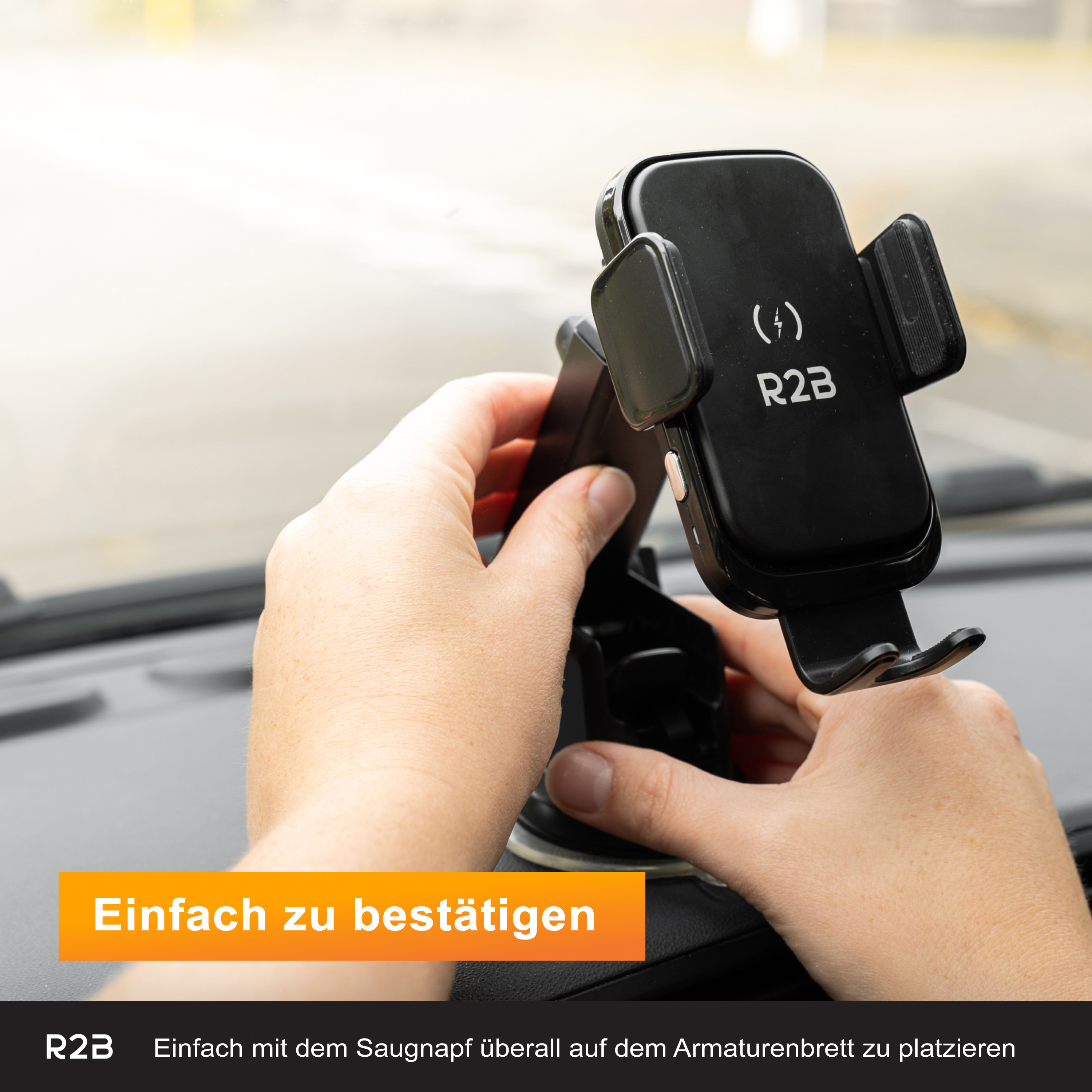Eine Person hält eine schwarze Handyhalterung mit Saugnapf an einem Armaturenbrett.