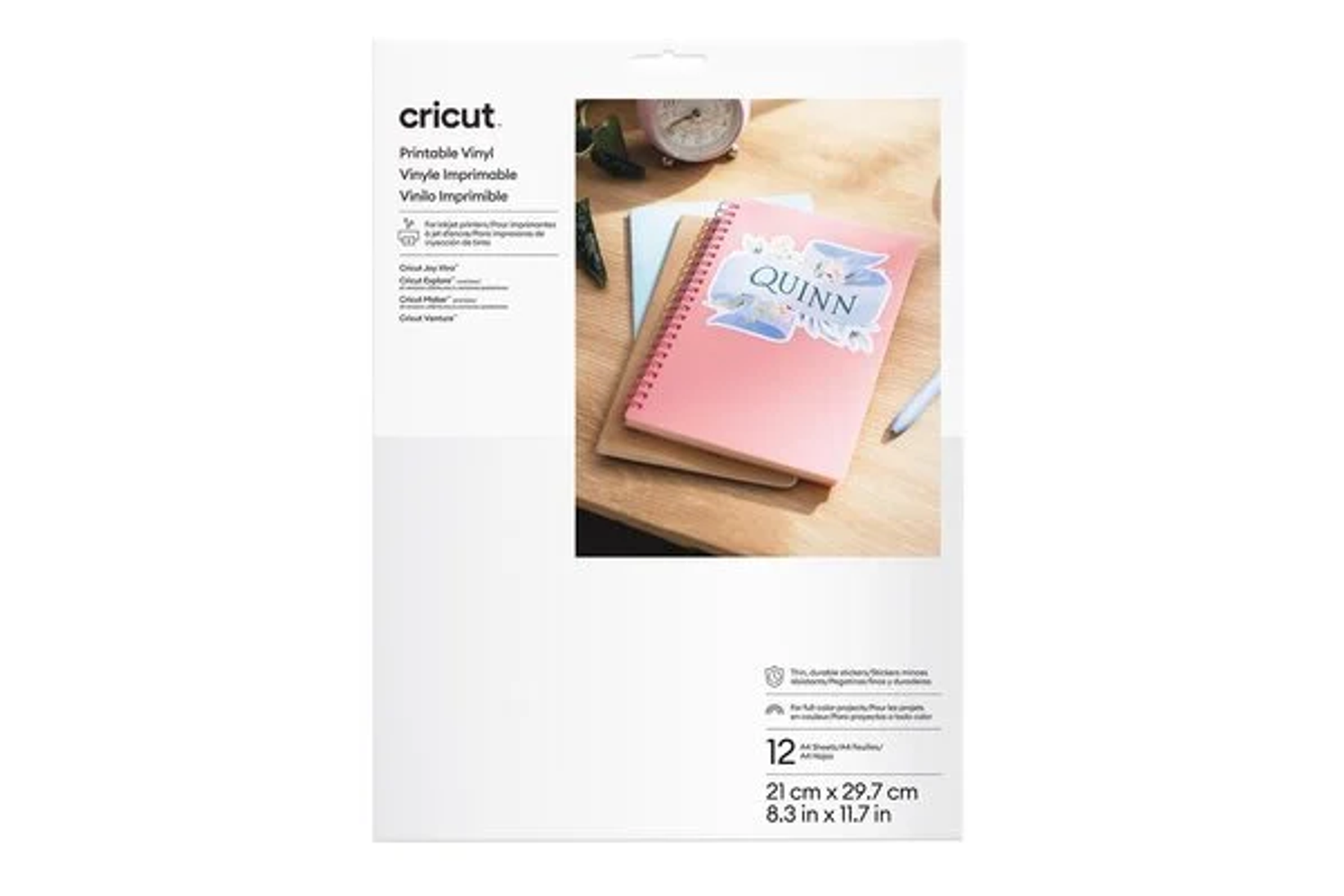 Vinilo imprimible Cricut. Un cuaderno con pegatina "QUINN" descansa sobre una mesa de madera.