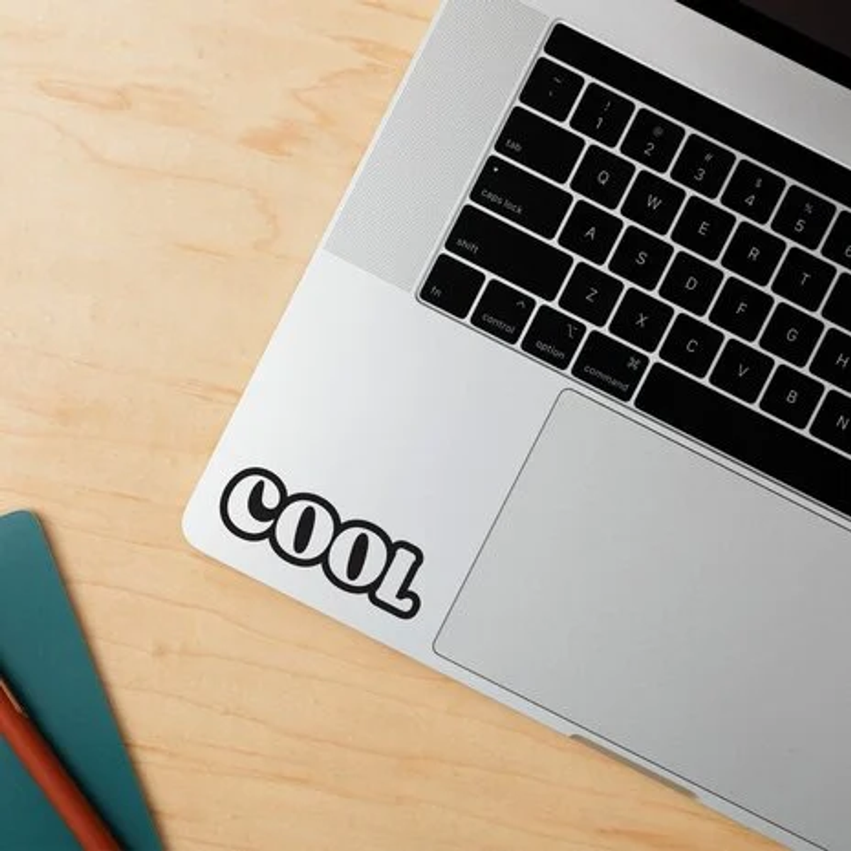 Un portátil con teclado negro y una pegatina que dice COOL.