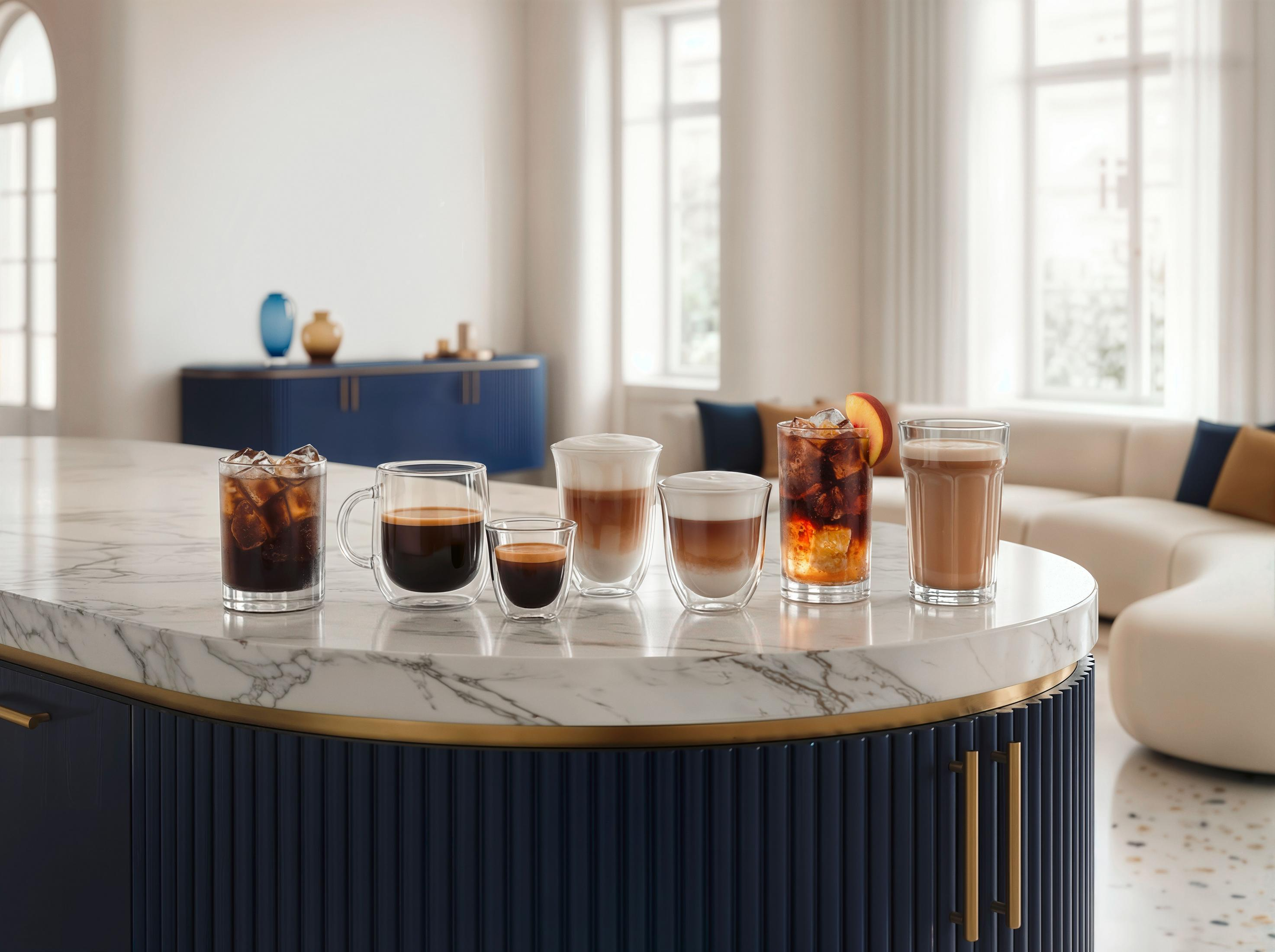 Seis vasos de bebidas de café sobre un mostrador de mármol, sofá al fondo.