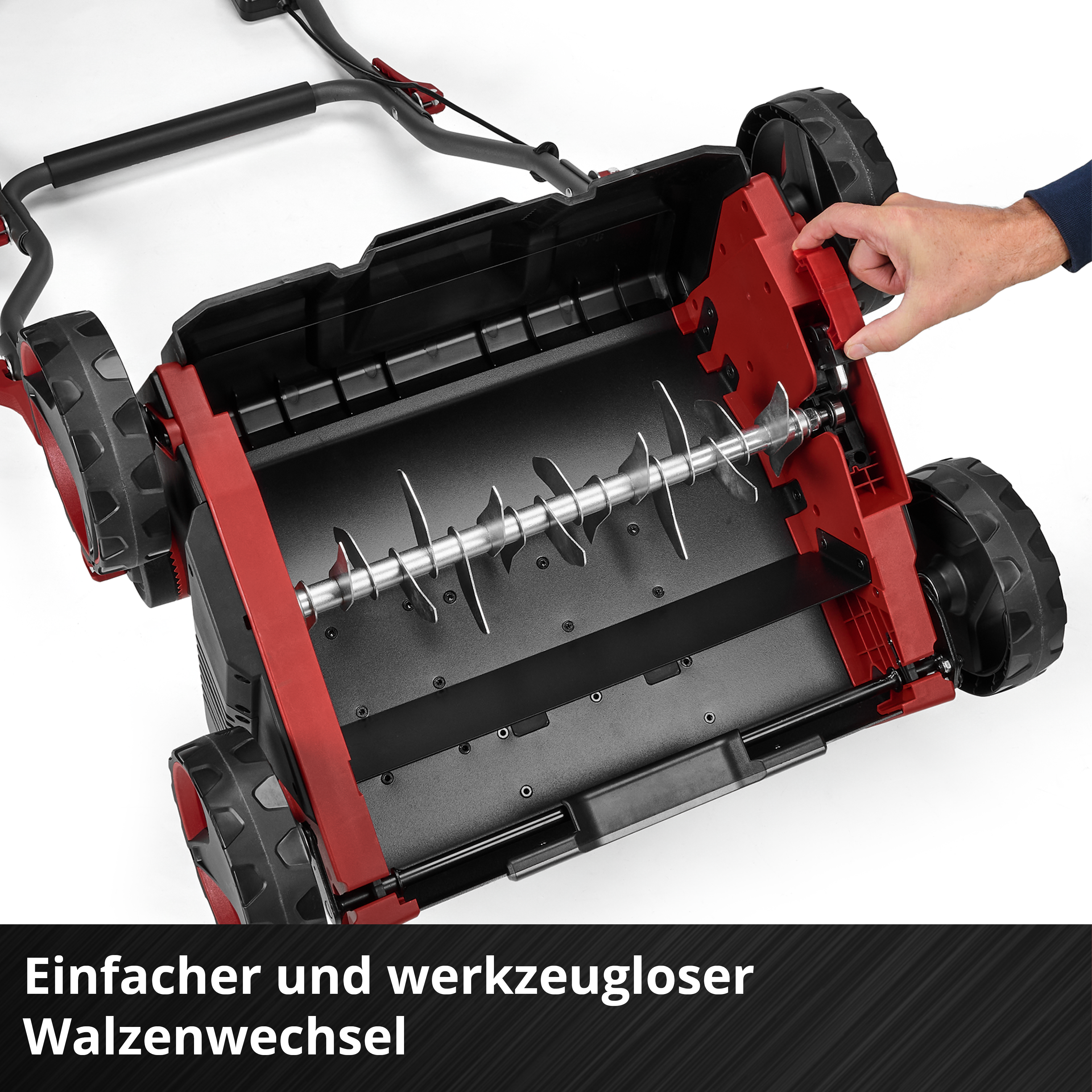 Ein Mann wechselt mit der Hand Werkzeuglos eine Walze an einem Rasenmäher.