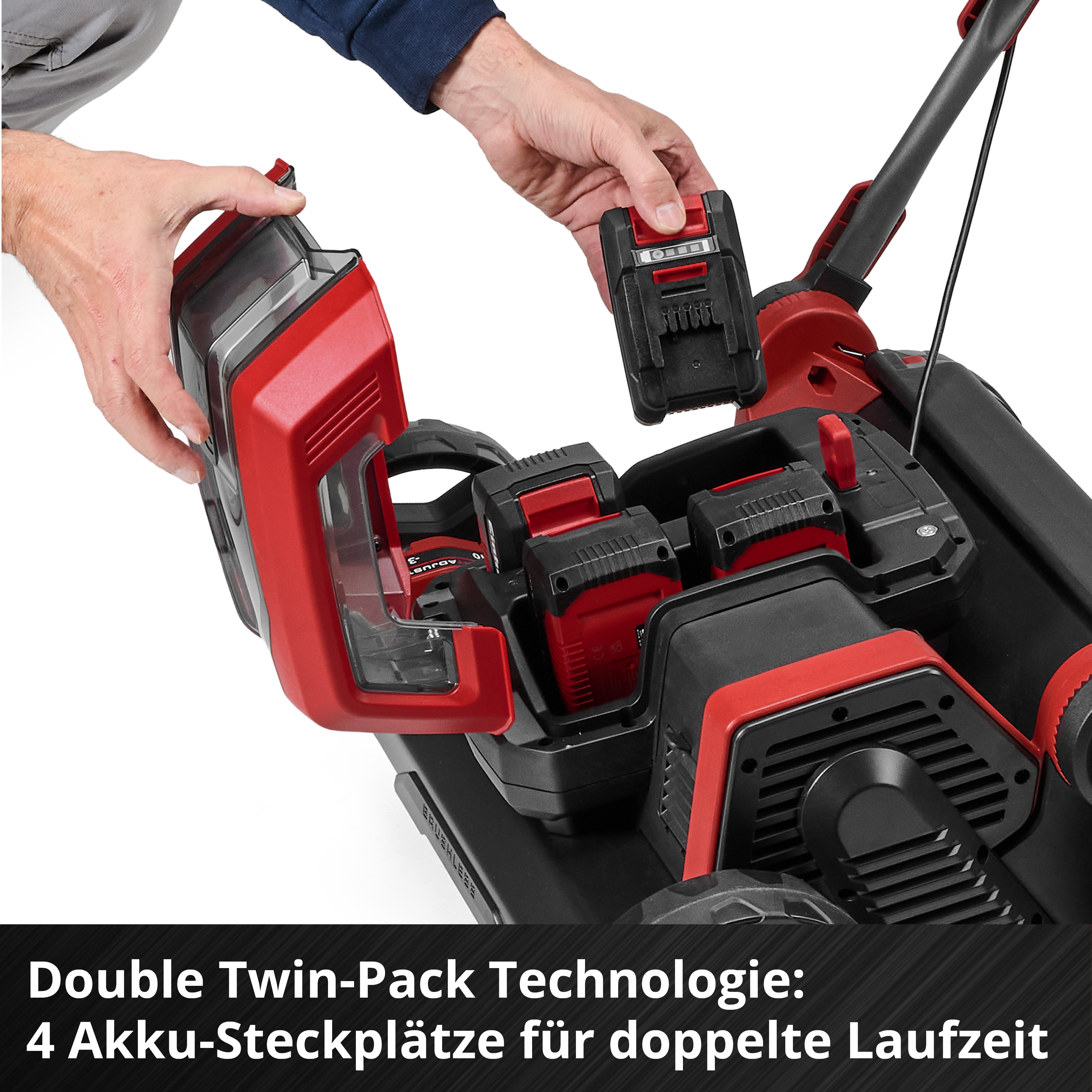 Ein Mann tauscht einen Akku in einem roten und schwarzen Rasenmäher mit vier Steckplätzen.