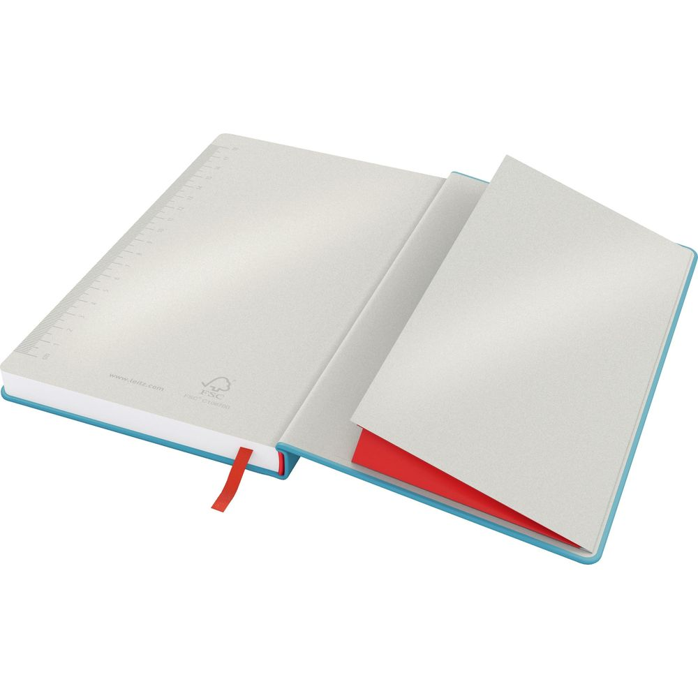 Ein offenes Notizbuch mit blauem Einband. Die Seiten sind hellgrau und haben eine Skala.