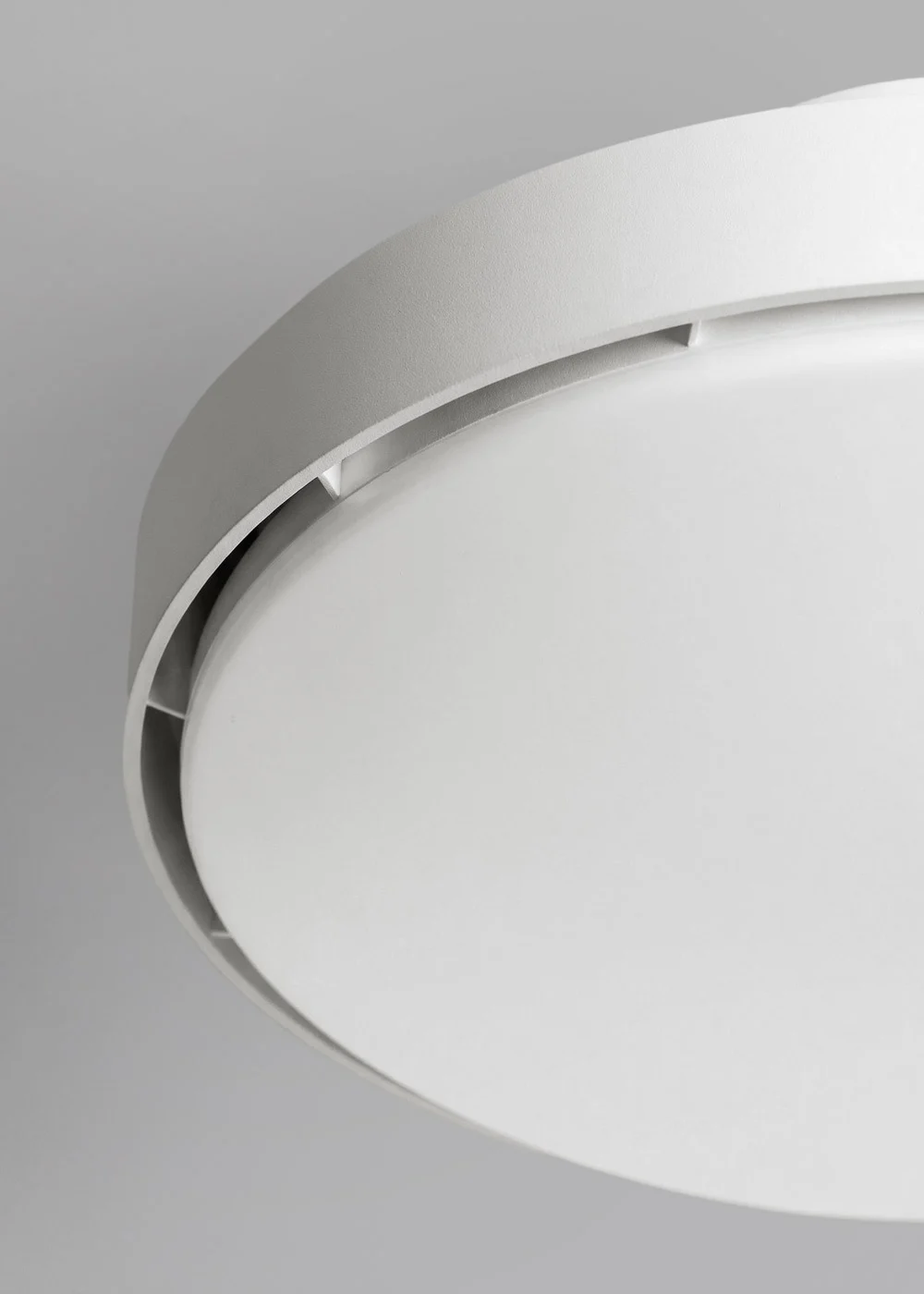 Primer plano de una lámpara de techo blanca con borde gris.