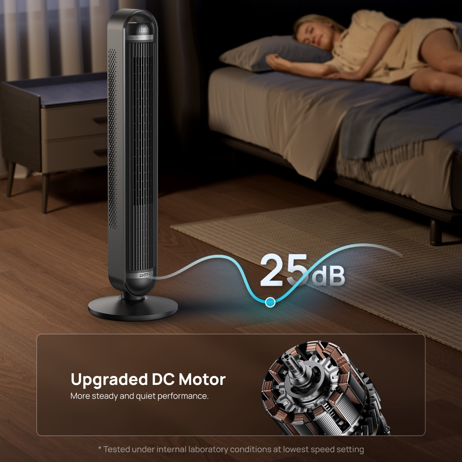 Un ventilateur tour noir à côté d'un lit où dort une femme. 25dB.