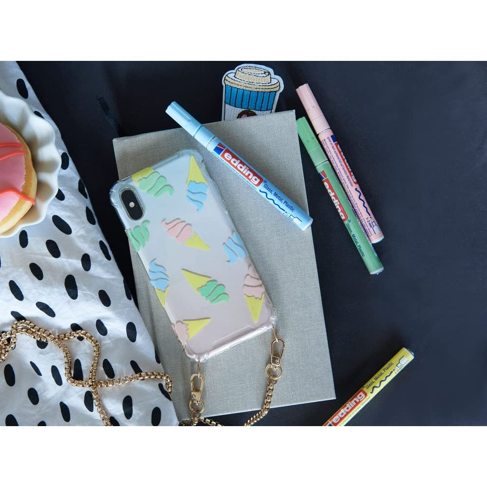 Ein Handycover mit Eiscreme-Motiv, Stifte und eine Kette auf einem schwarzen Hintergrund.