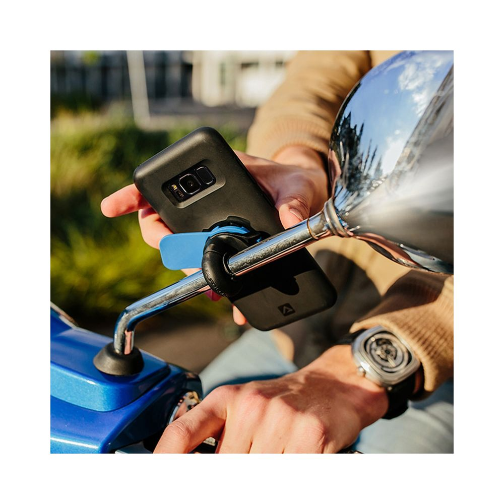 Eine Hand hält ein Smartphone an einem Motorradspiegelhalter.