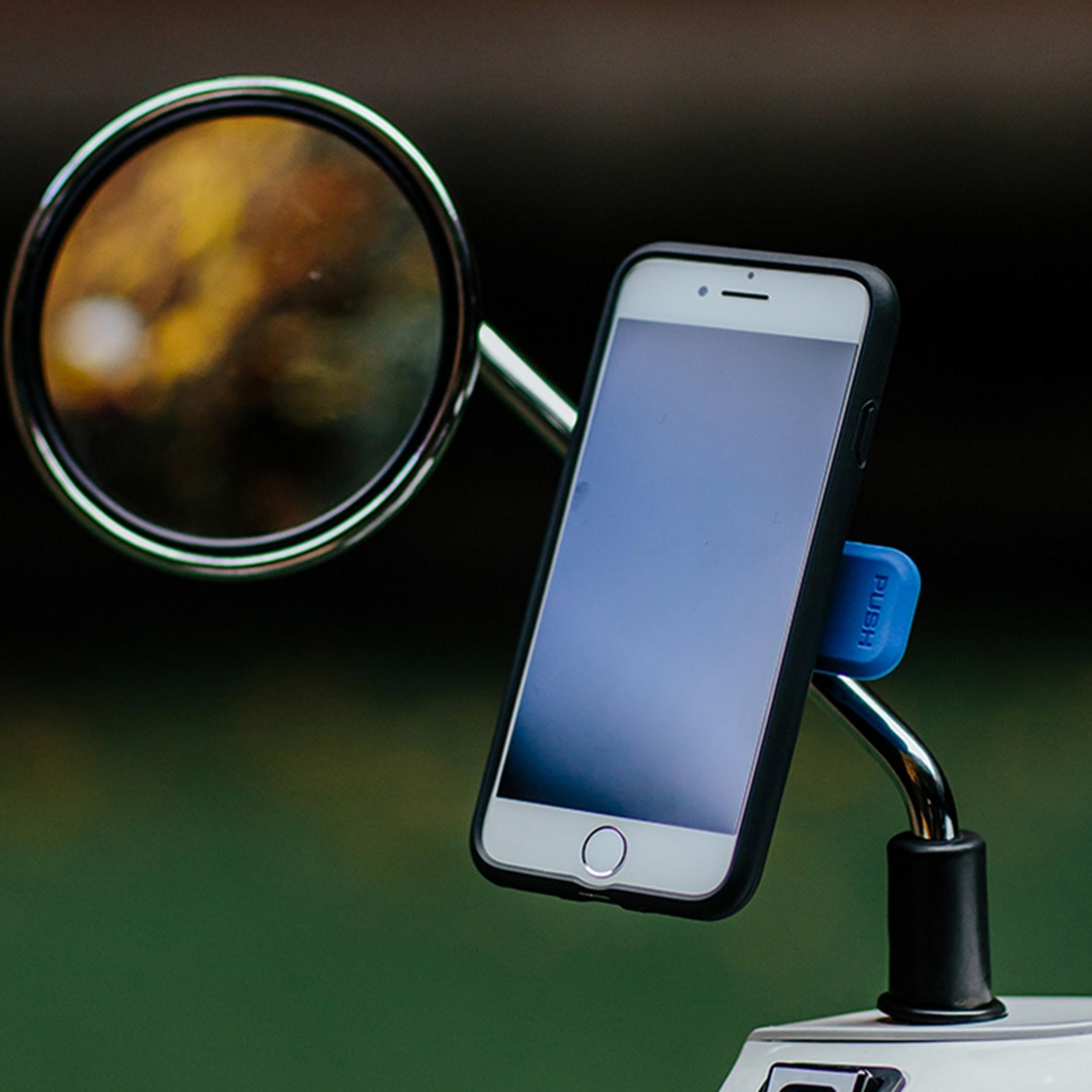 Ein Smartphone in einer Halterung neben einem Motorradspiegel.