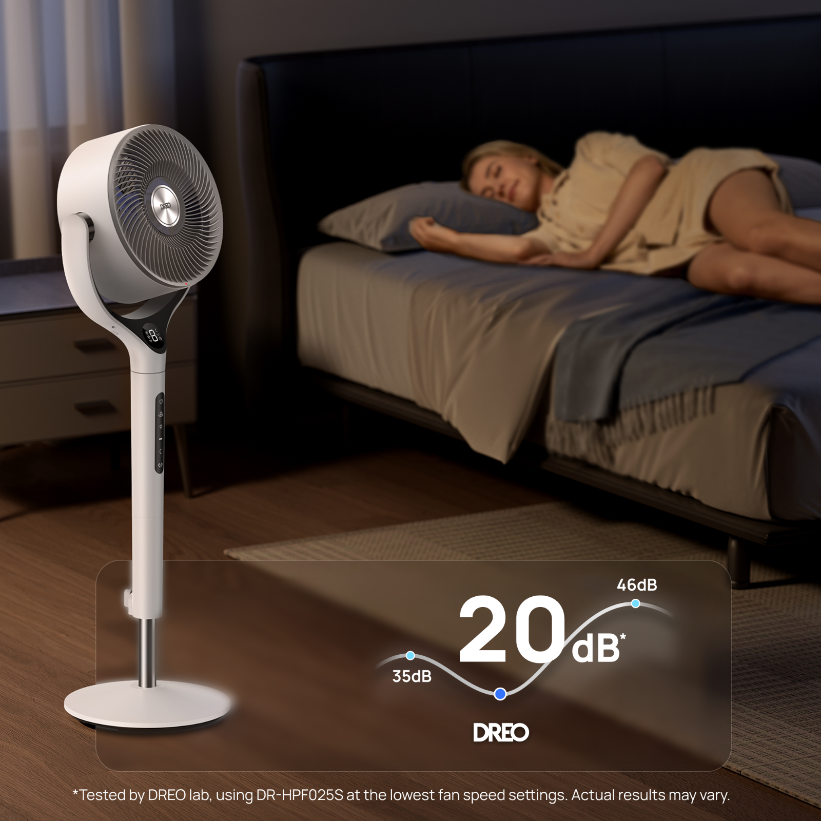 Un ventilateur blanc se trouve dans une chambre à côté d'un lit où une femme dort.