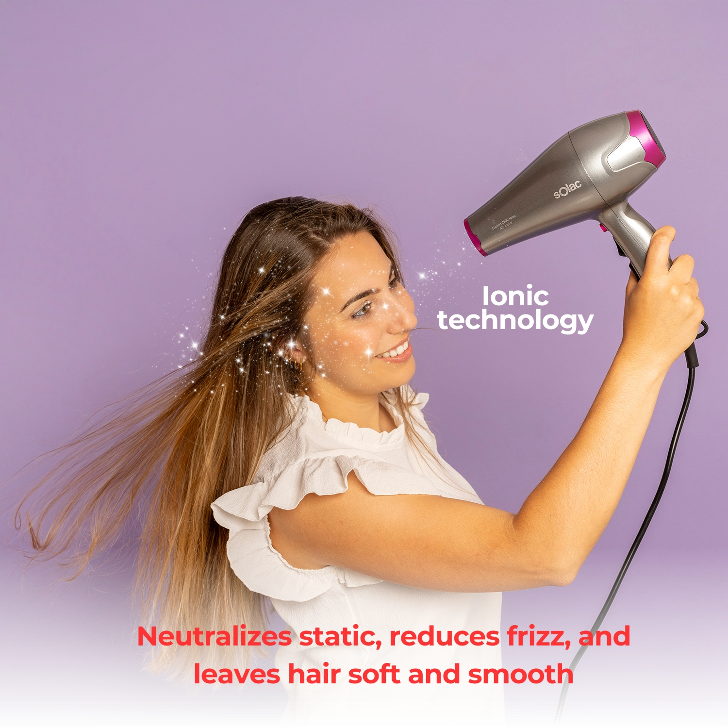 Mujer secándose el pelo con un secador plateado y rosa, mostrando tecnología iónica.