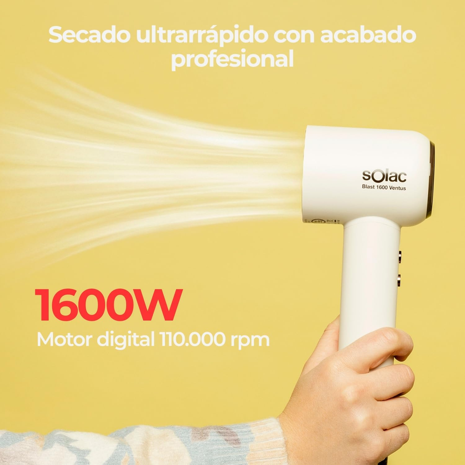 Una mano sostiene un secador de pelo blanco Solac que emite una fuerte corriente de aire sobre un fondo amarillo.