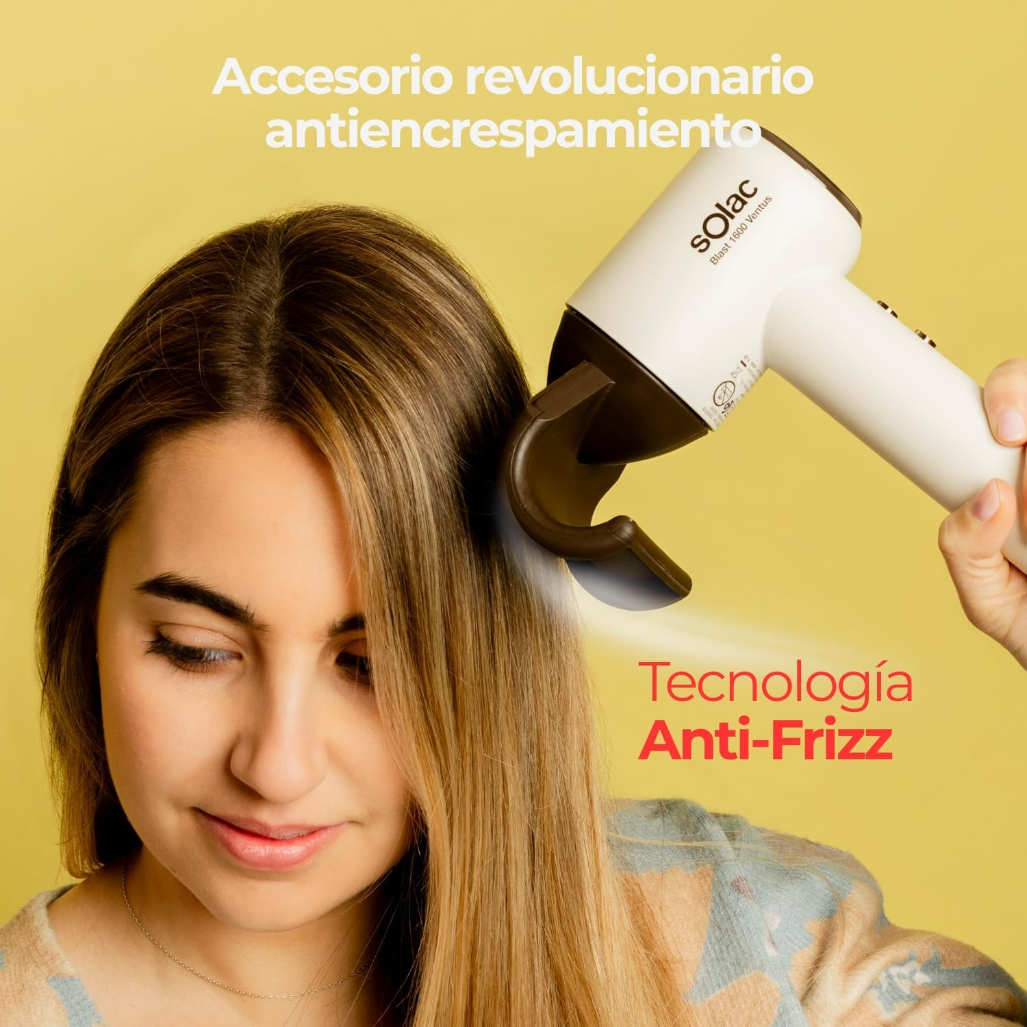 Una mujer usa un secador blanco con accesorio marrón en su pelo rubio.