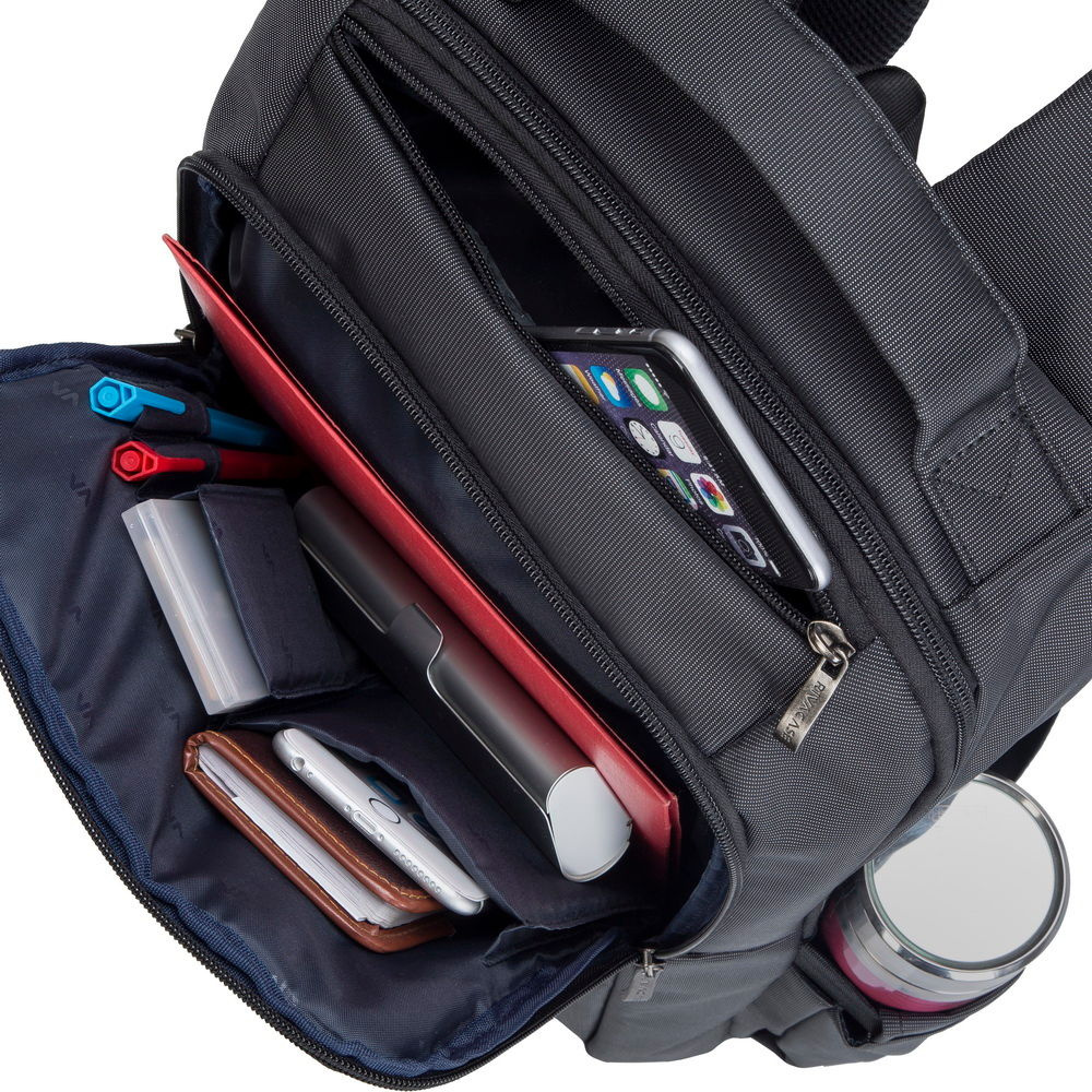 Grijze tas met open vakken met pennen, telefoon, notitieboekje en thermosfles.