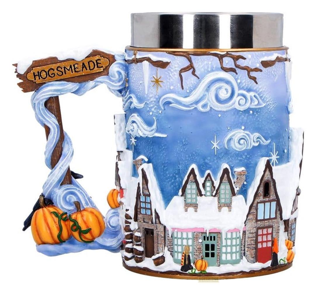 Una taza con letrero de Hogsmeade, pueblo invernal, calabazas y nieve.