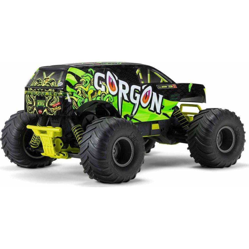 Un monster truck negro con diseño verde de Gorgona y ruedas grandes.