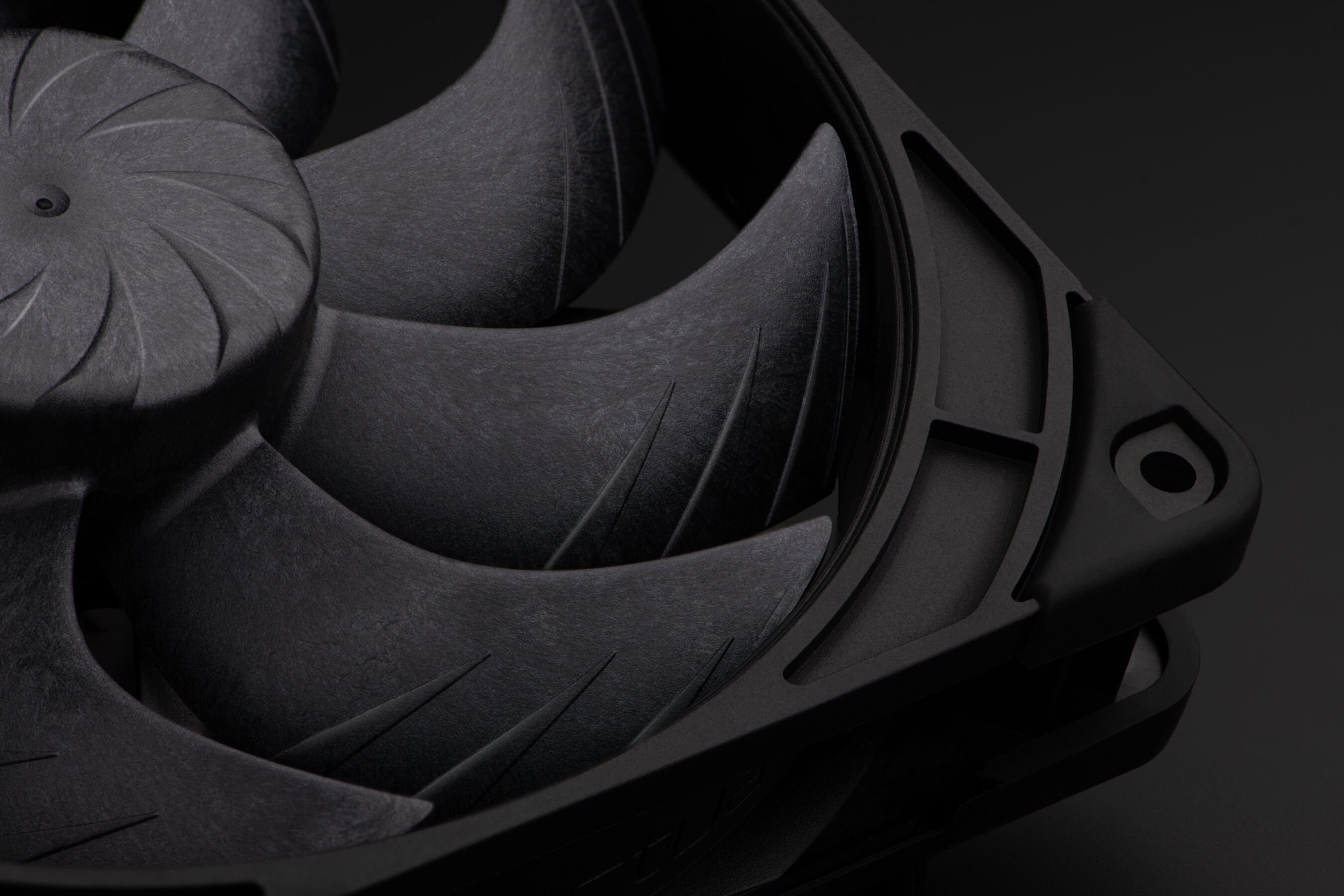 Primo piano di una ventola per computer nera con pale curve su sfondo scuro.