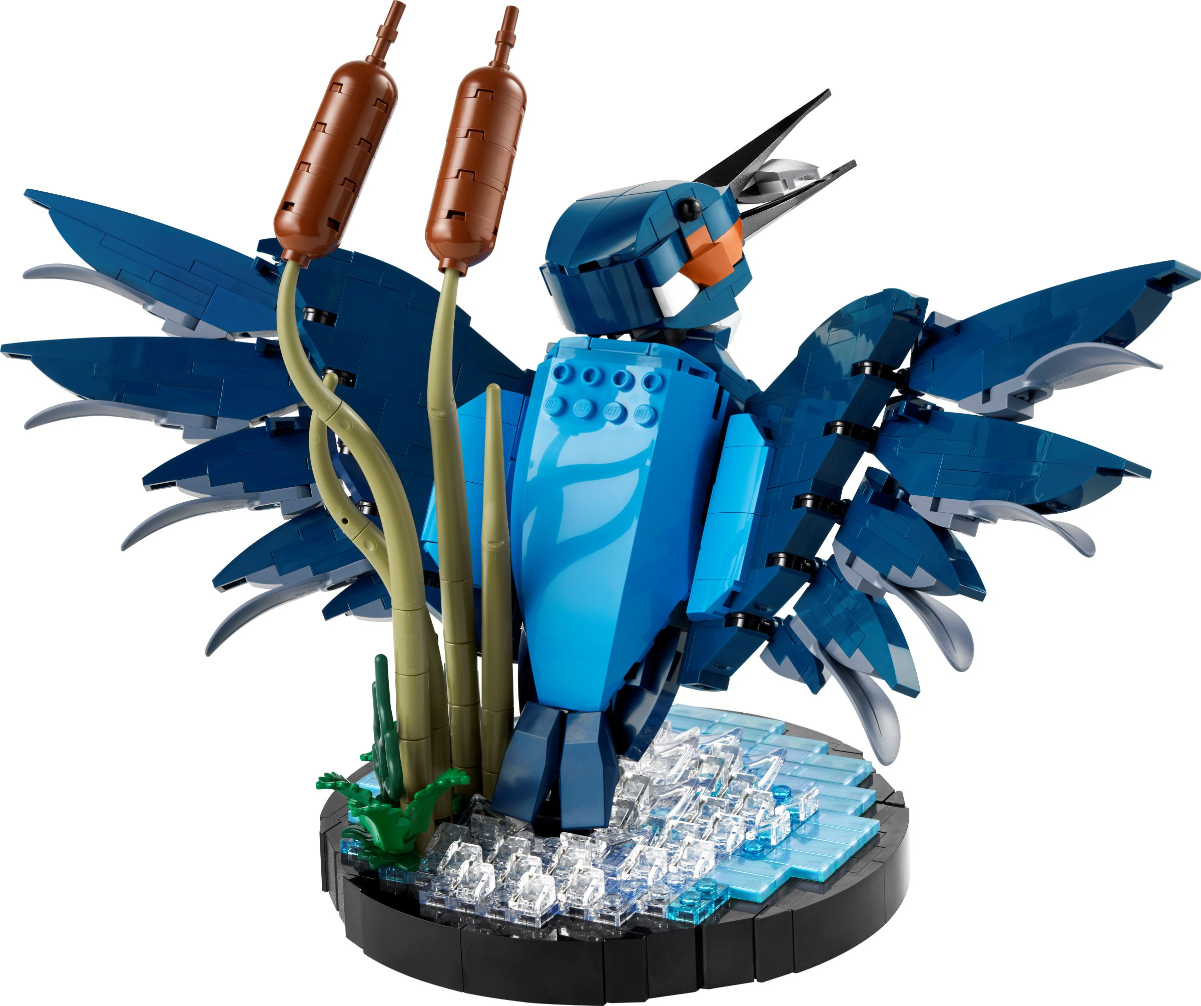 Ein blauer Lego-Vogel mit ausgebreiteten Flügeln steht auf Eis und Pflanzen.