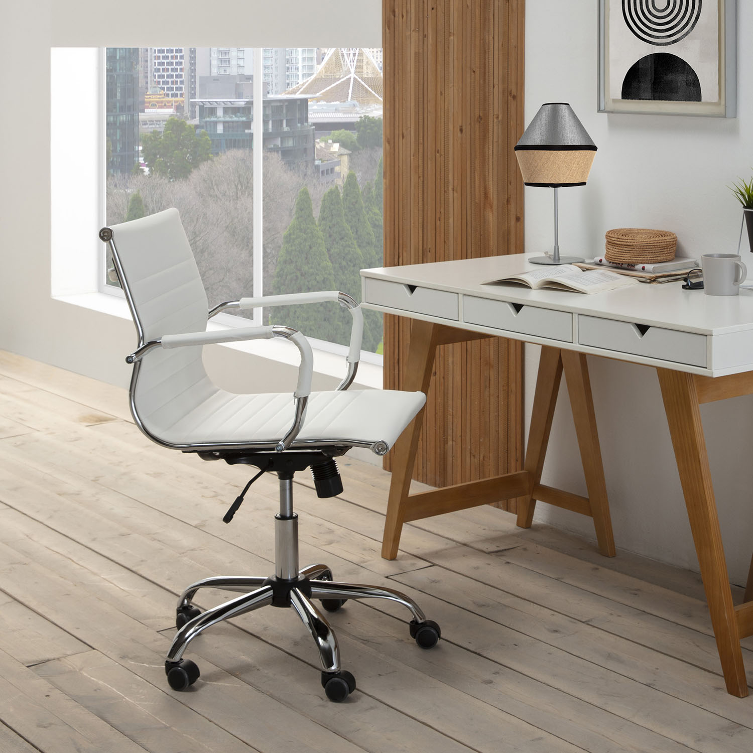 Silla de oficina blanca moderna frente a un escritorio con lámpara y libro.
