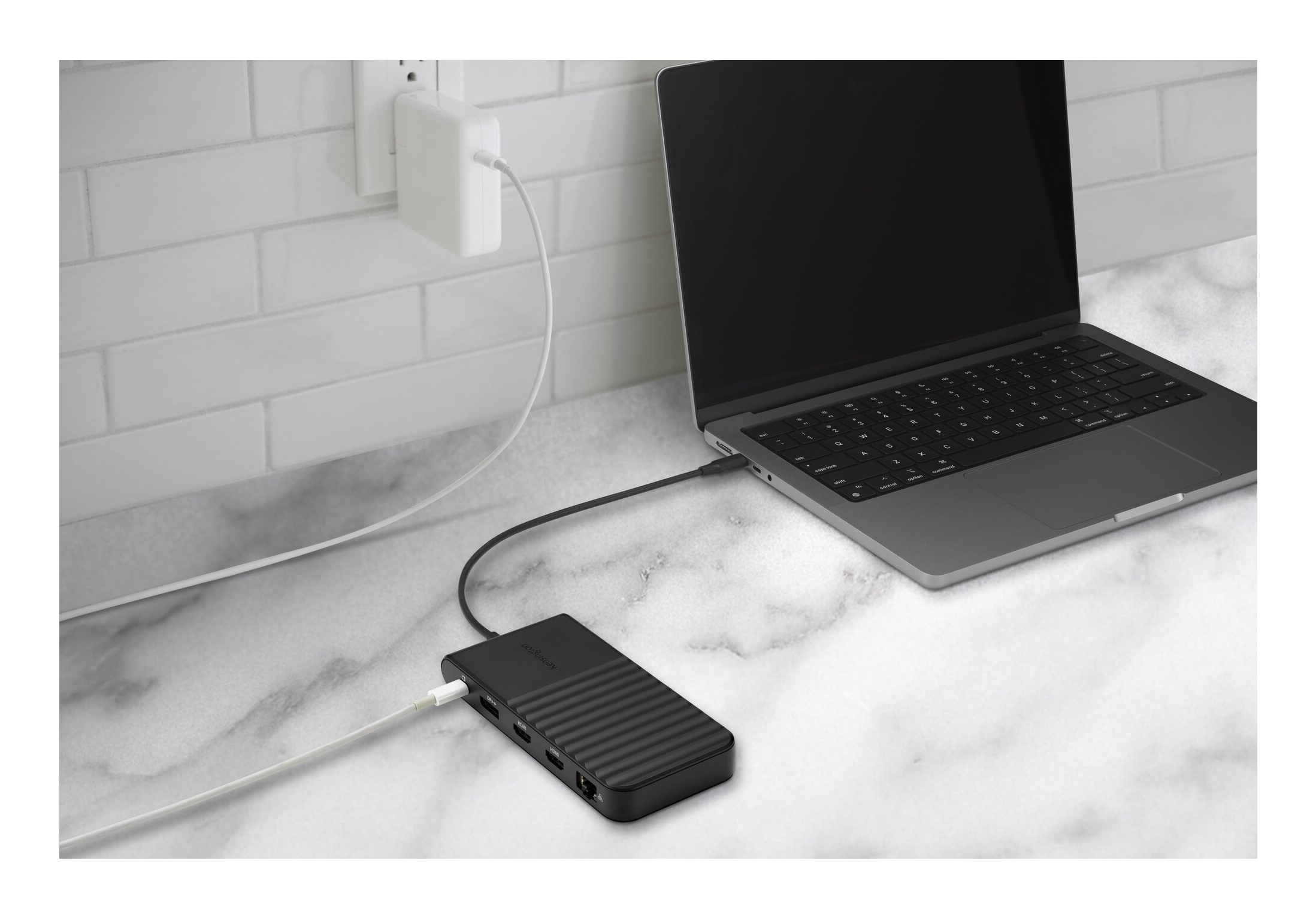 Un laptop nero è collegato a un hub collegato a una presa di corrente.