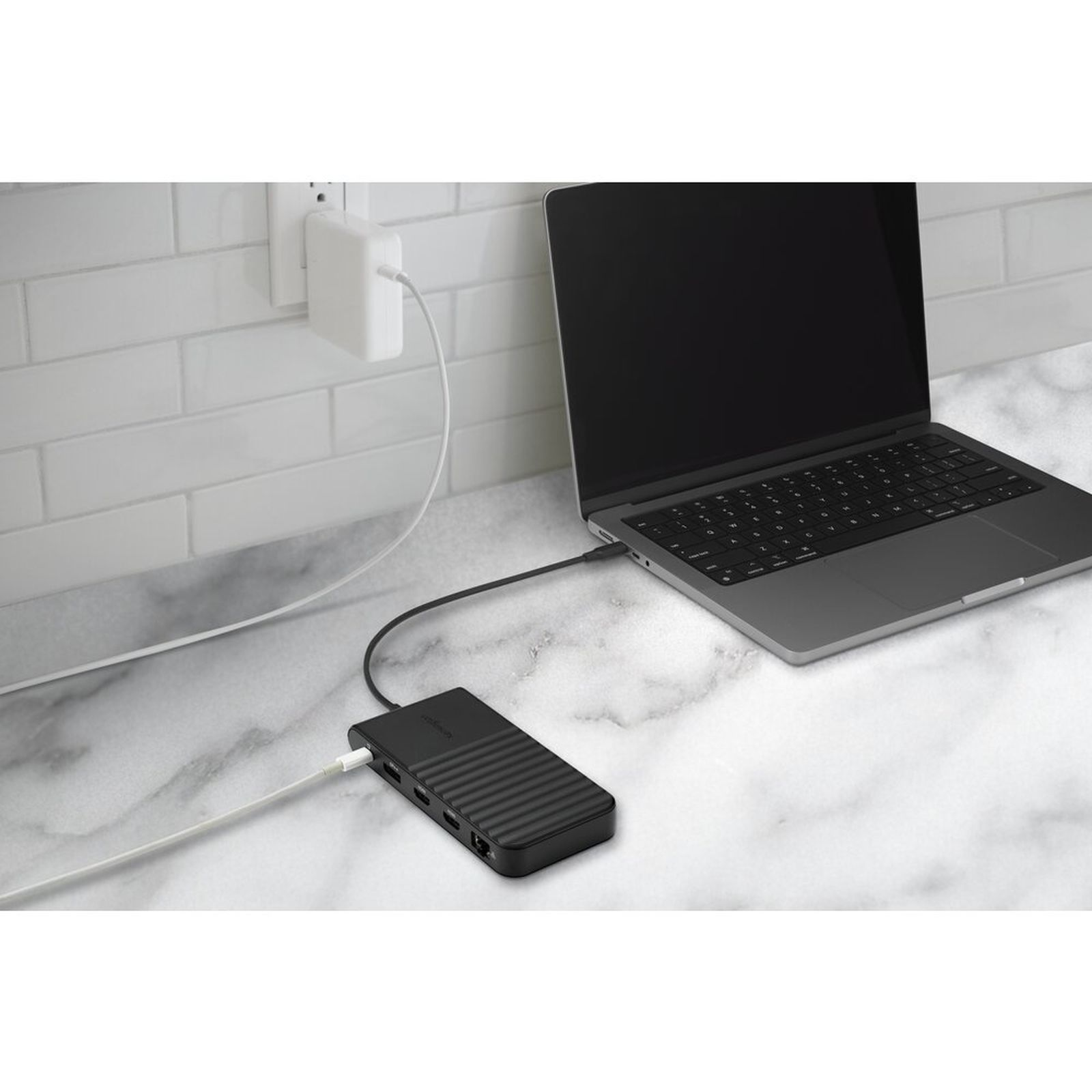 Un laptop è collegato a una docking station collegata a una presa a muro.