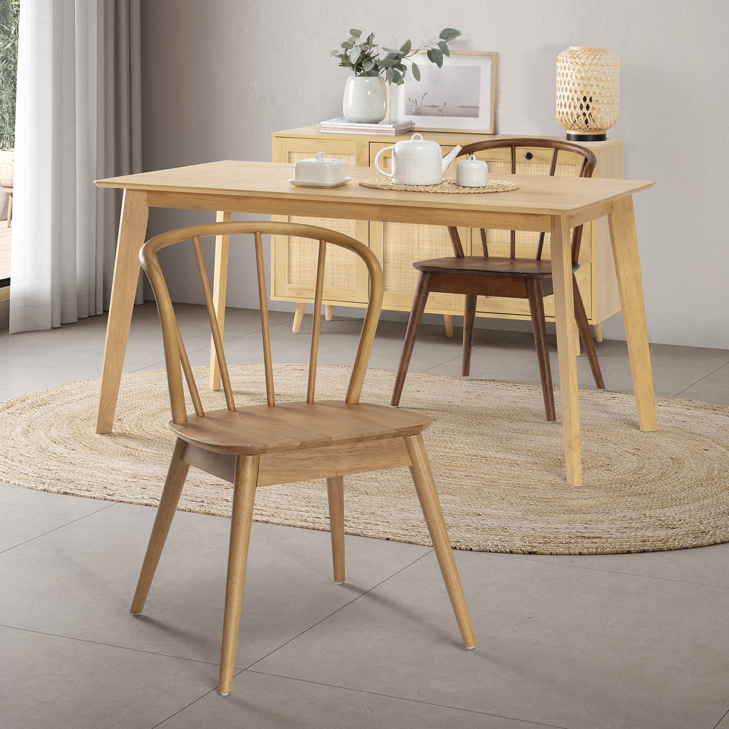Mesa de comedor de madera clara con sillas y un mueble tejido con decoración.