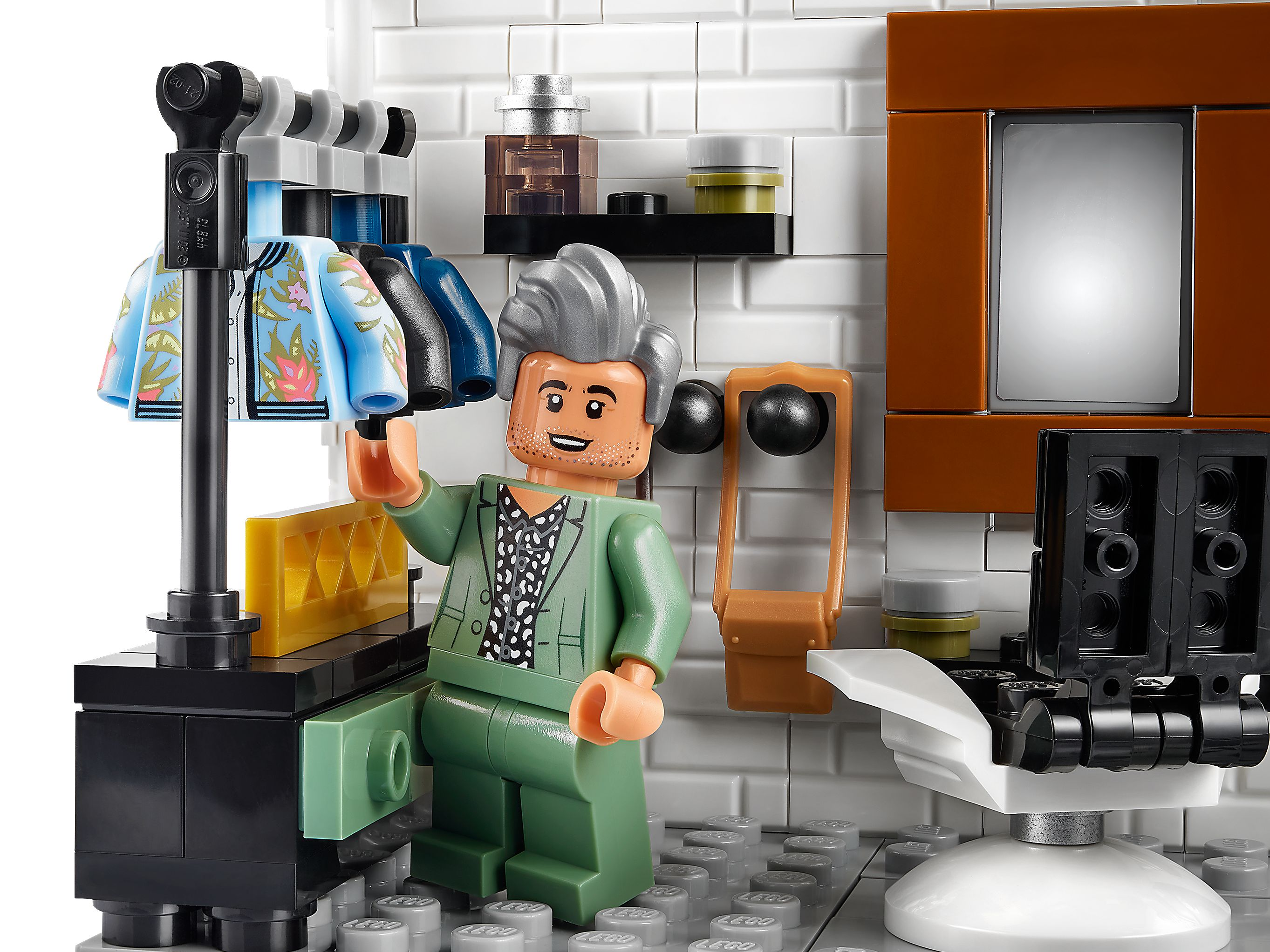 Ein Lego-Mann in einem grünen Anzug steht vor einer Kleiderstange mit bunten Jacken.
