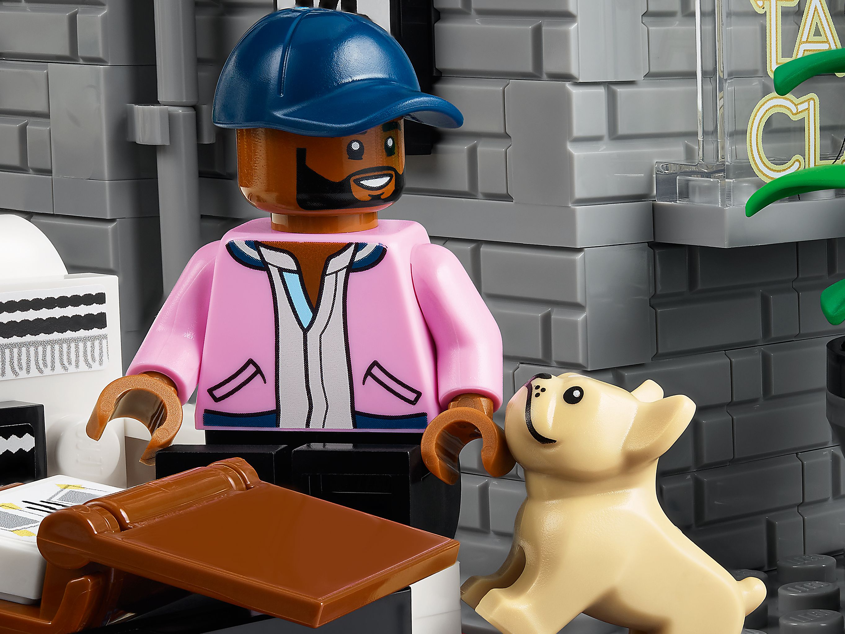 Ein Lego-Mann mit blauer Kappe und rosa Jacke neben einem hellbeigen Lego-Hund.
